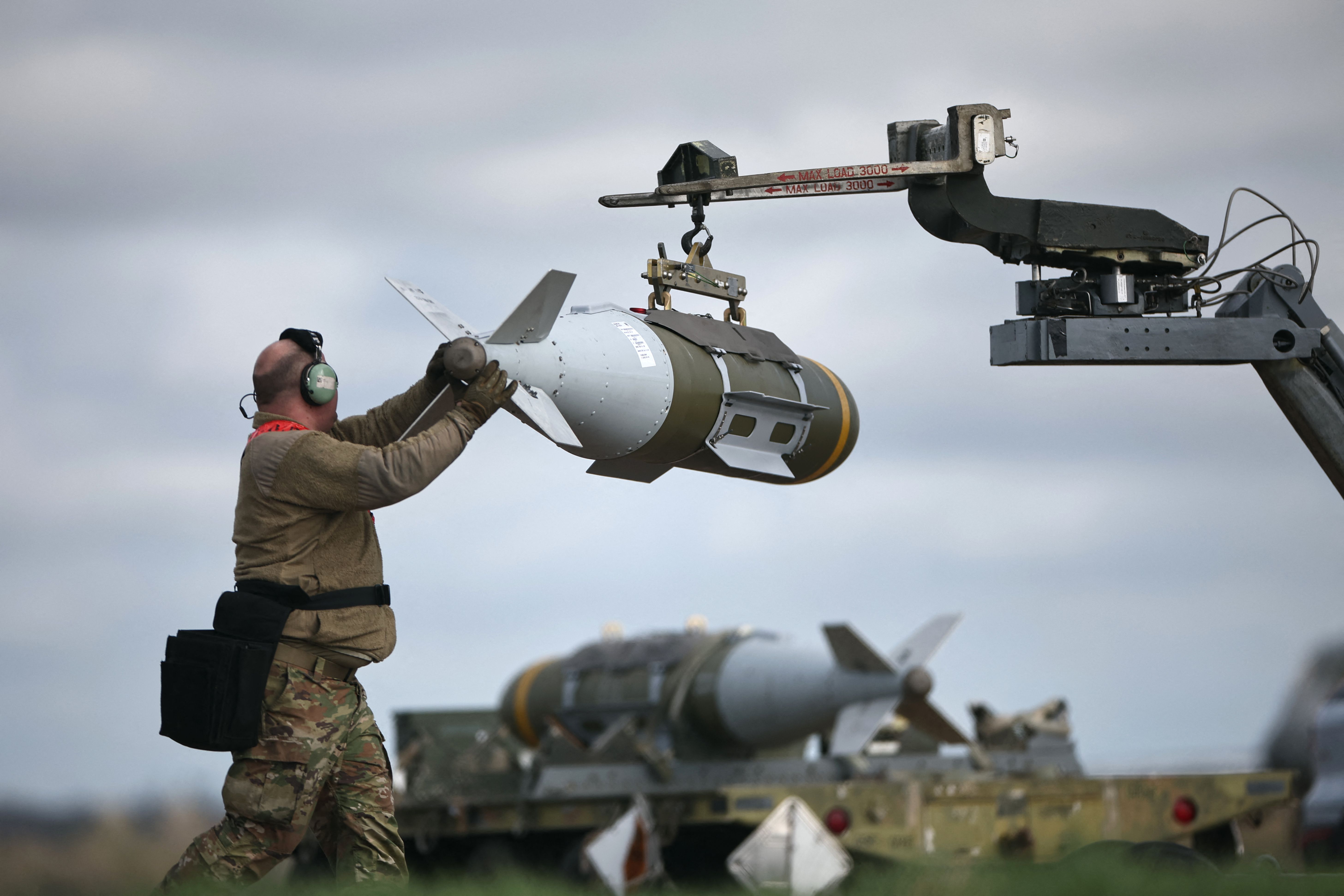 U.S. military personnel remove JDAM bombs from a B-1 Lancer bomber at the RAF Fairford airbase in southwest England yesterday. 