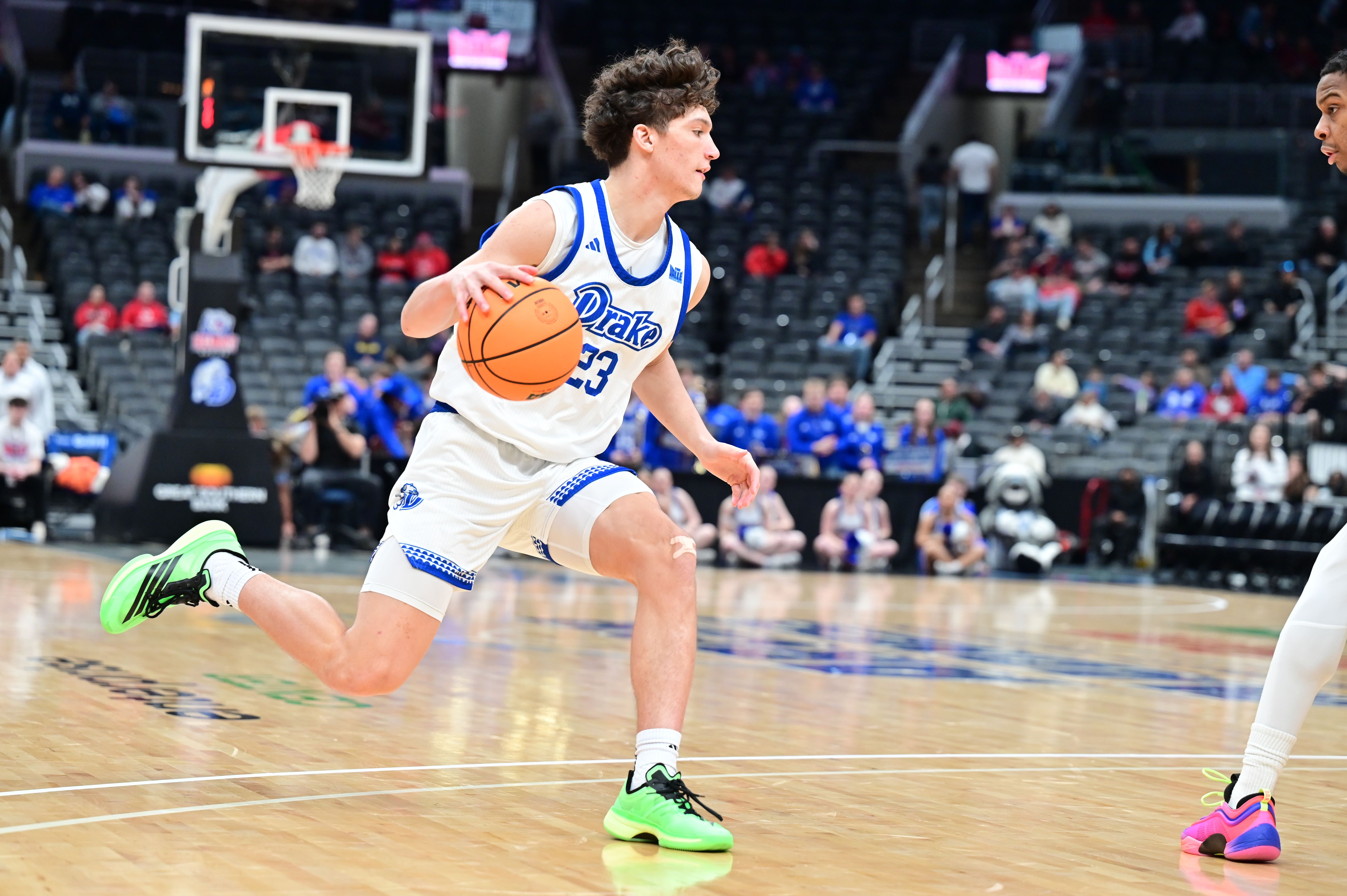 Photo of a player dribbling a basketball on a court. 