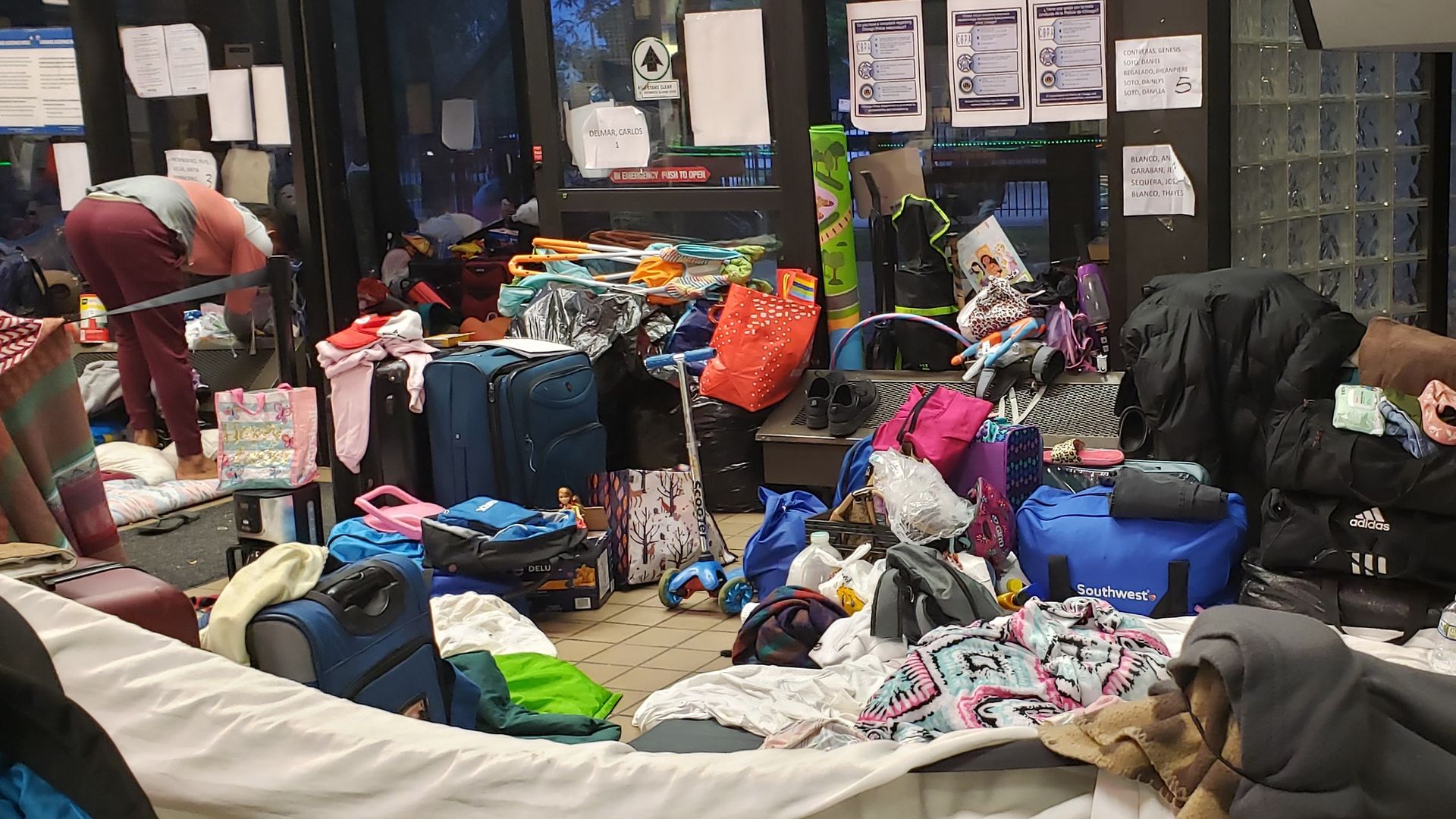 Room cluttered with bags, blankets and clothes