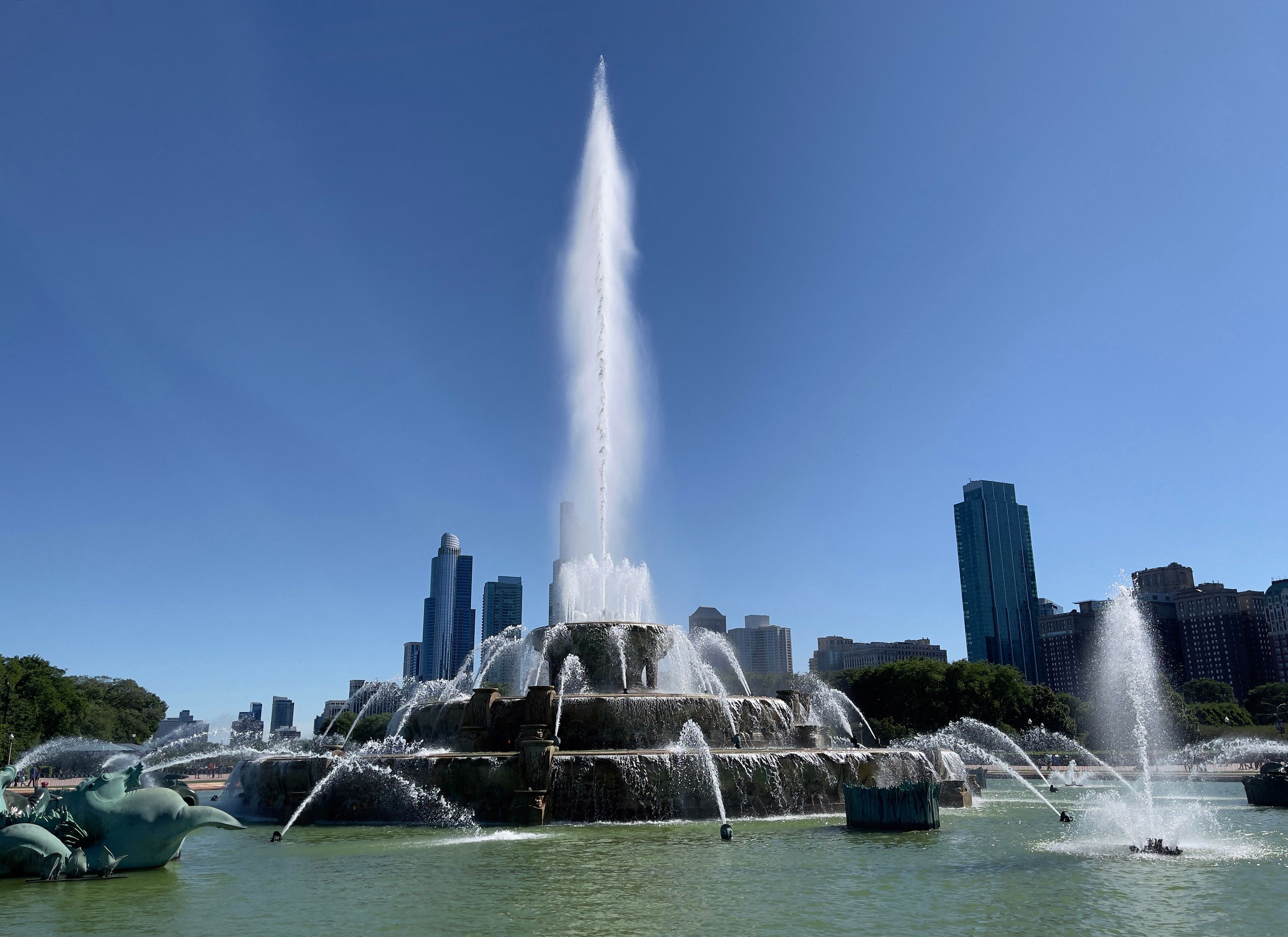 Water sprays from Chicago's Buckingham Fountain in Grant Park, with the city's skyline in the background.