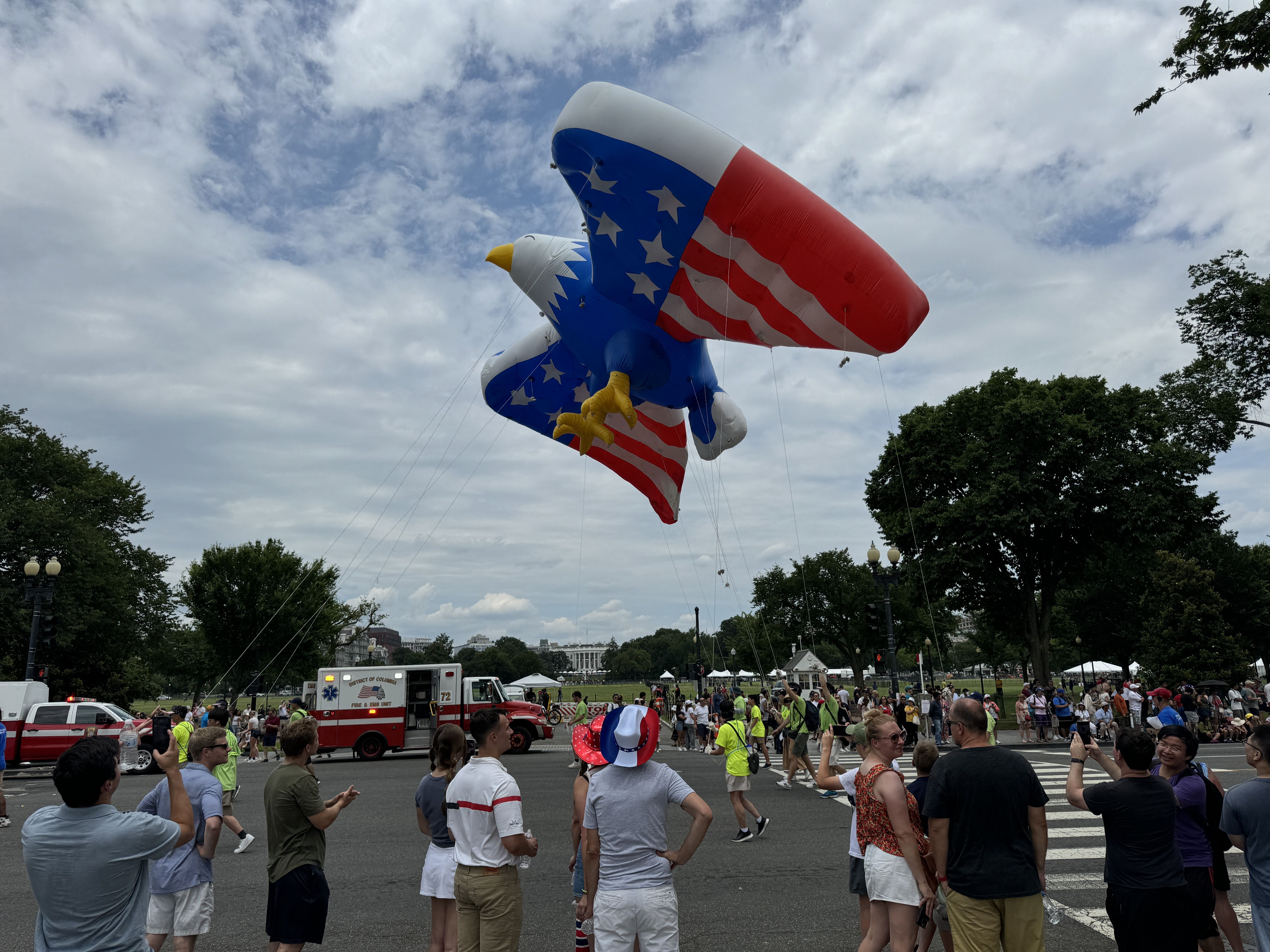 People pass the White House (C, rear) as they take part in a parade during celebrations marking Independence Day 