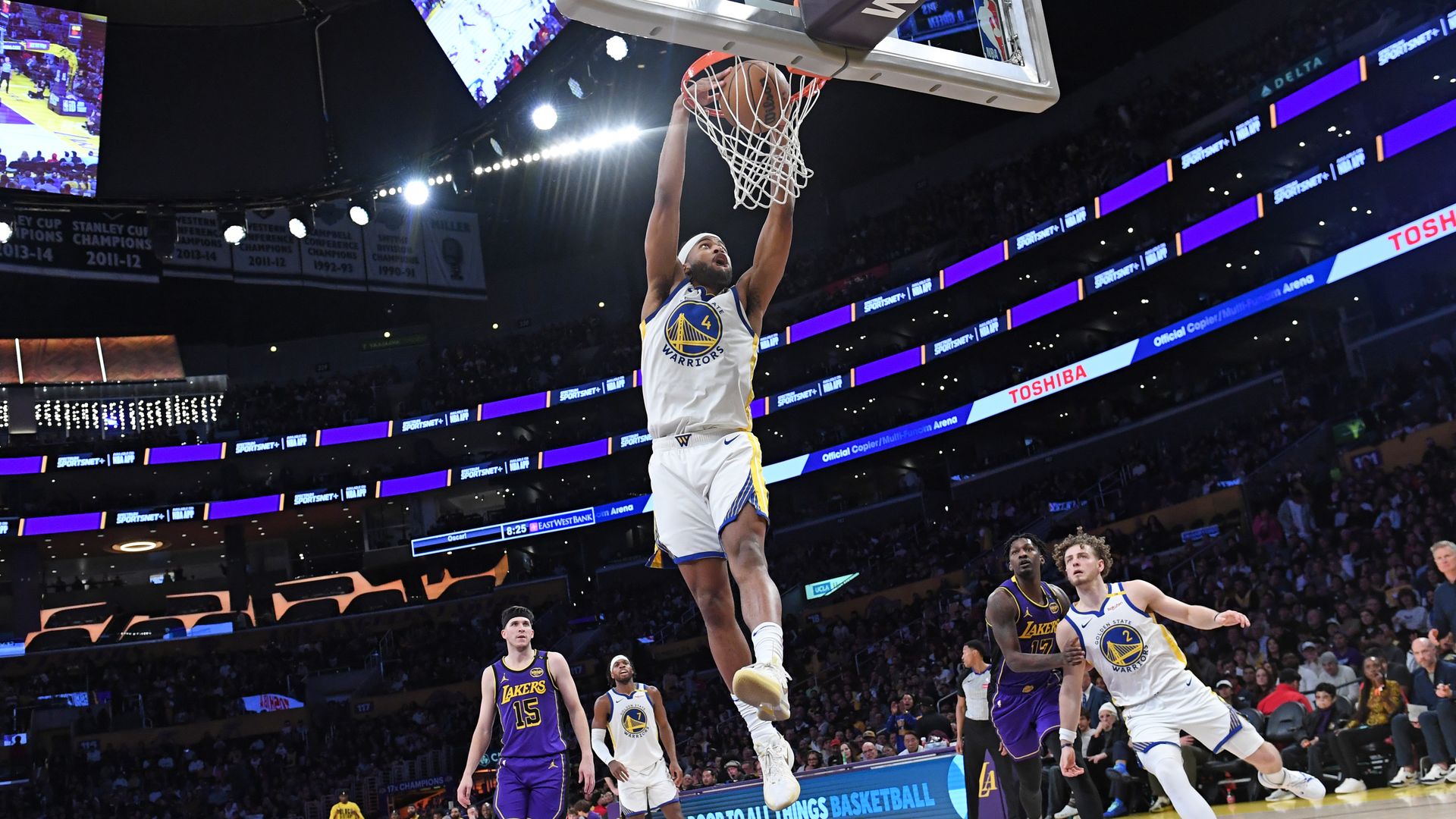 Photo of Moses Moody dunking a ball on the court as other players watch from behind