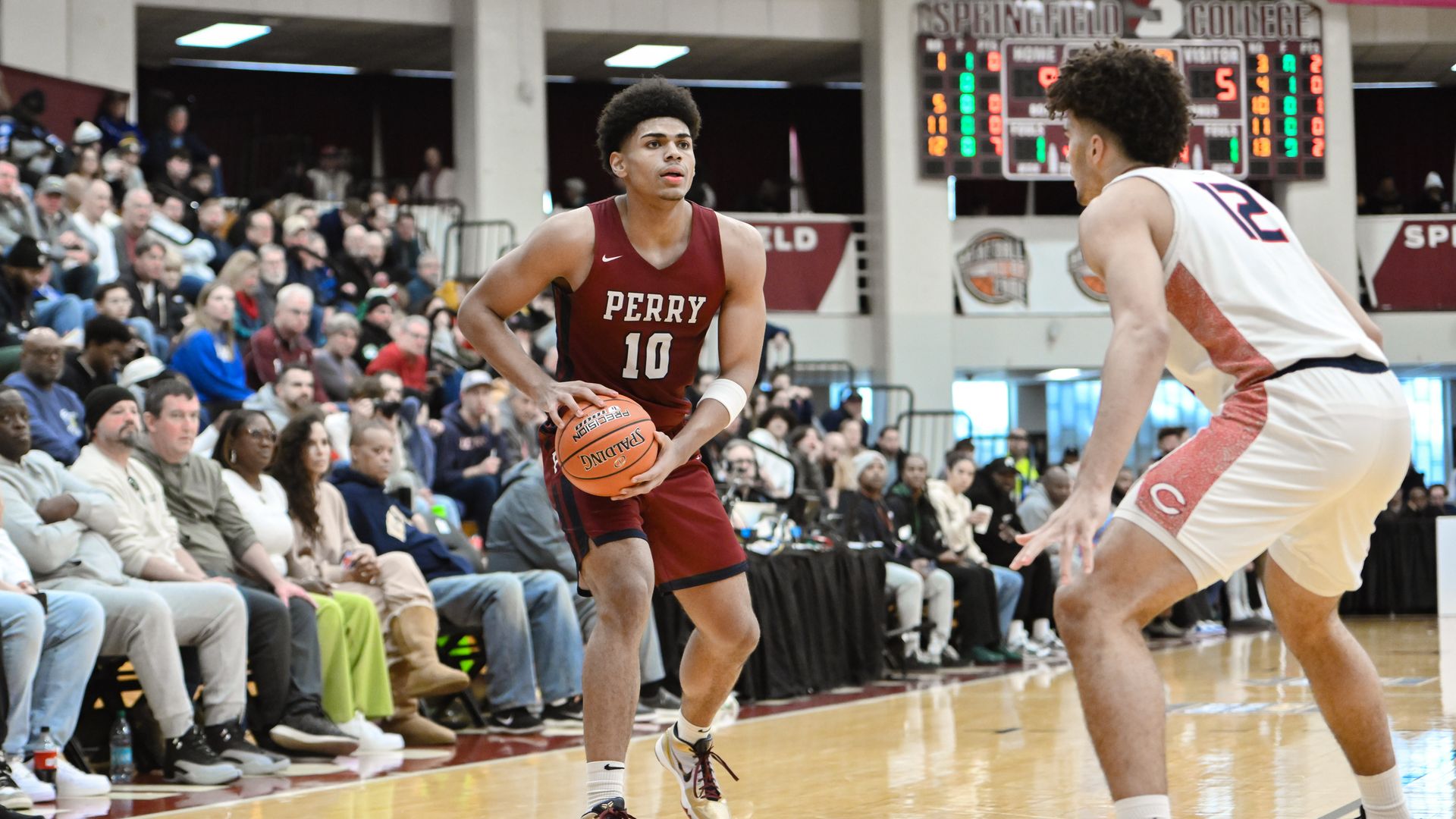Koa Peat holds the basketball while a defender guards him. 