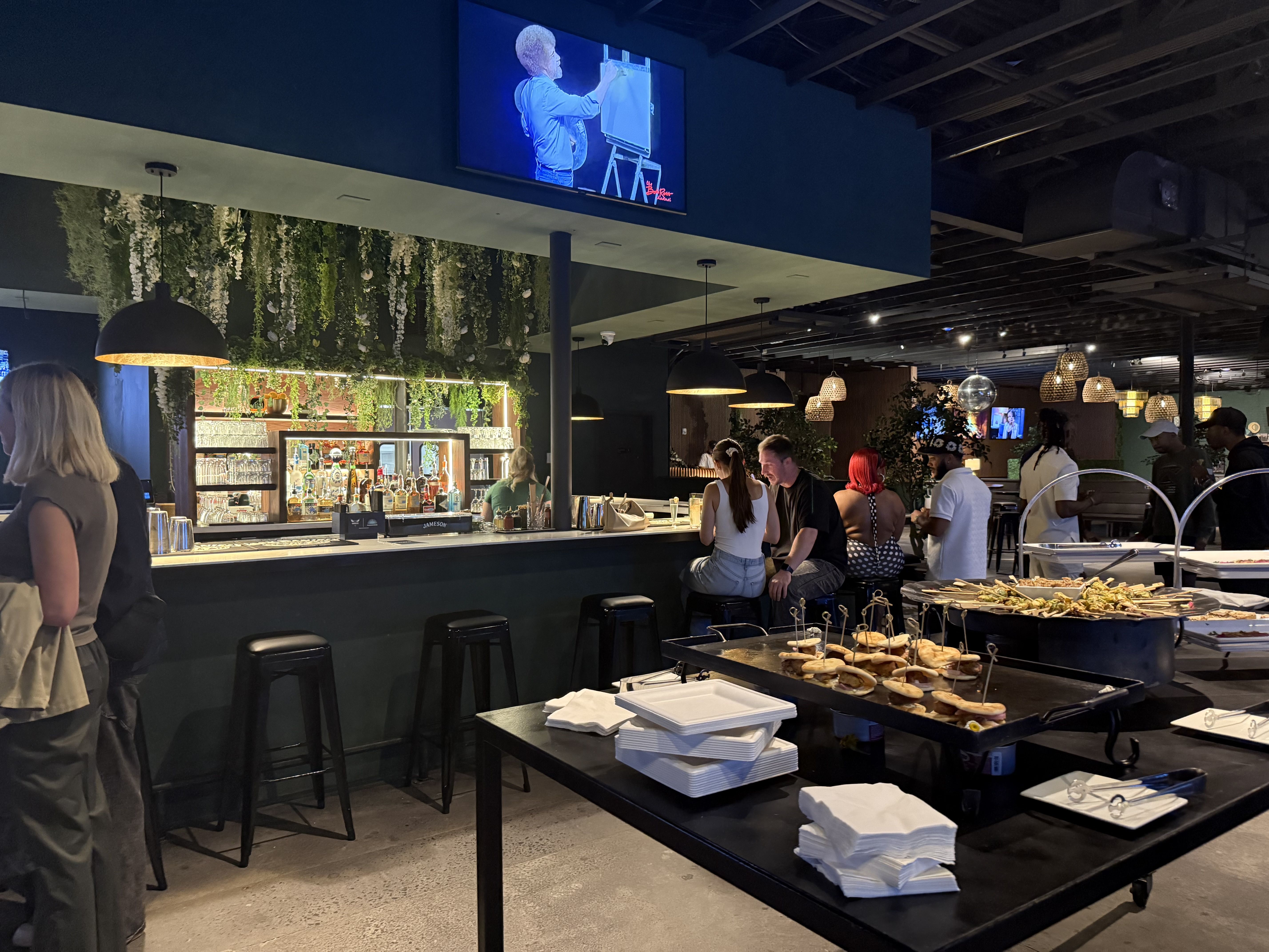 You'll find two fully stocked bars, one by the entrance, and this one, by the DJ booth. Photo: McKenzie Rankin/Axios