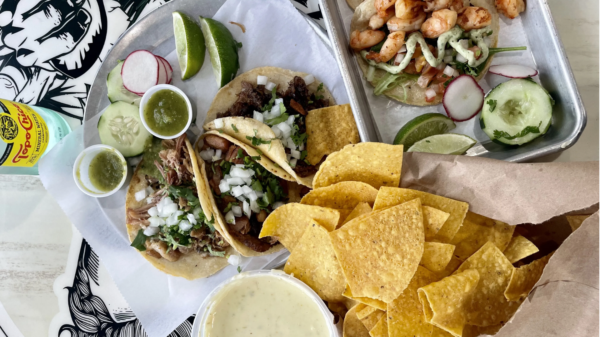 A spread of tacos, chips and queso