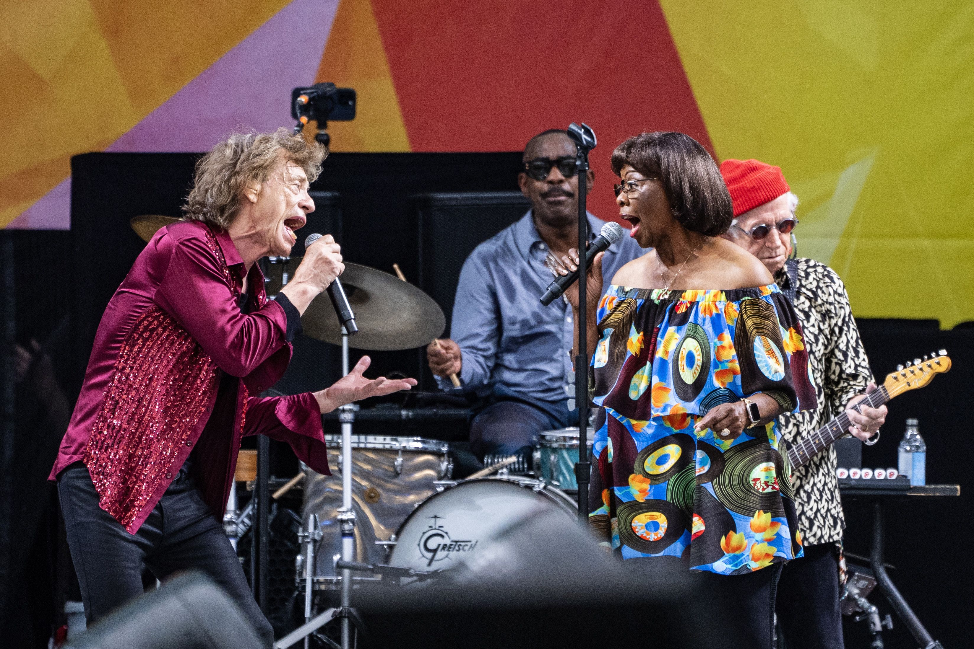 Mick Jagger and Irma Thomas sing onstage while looking at each other.