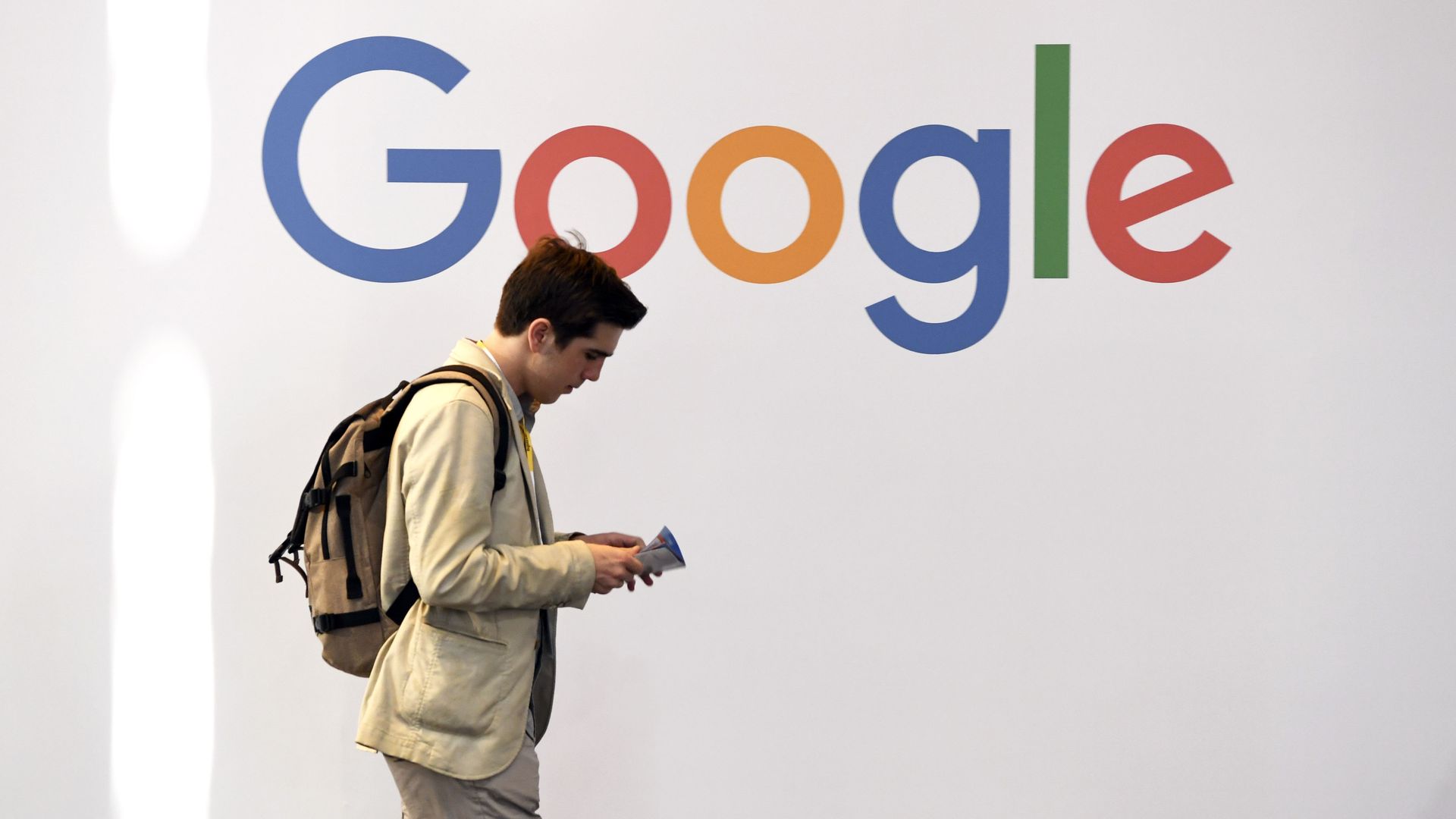 A man walks past Google's logo.