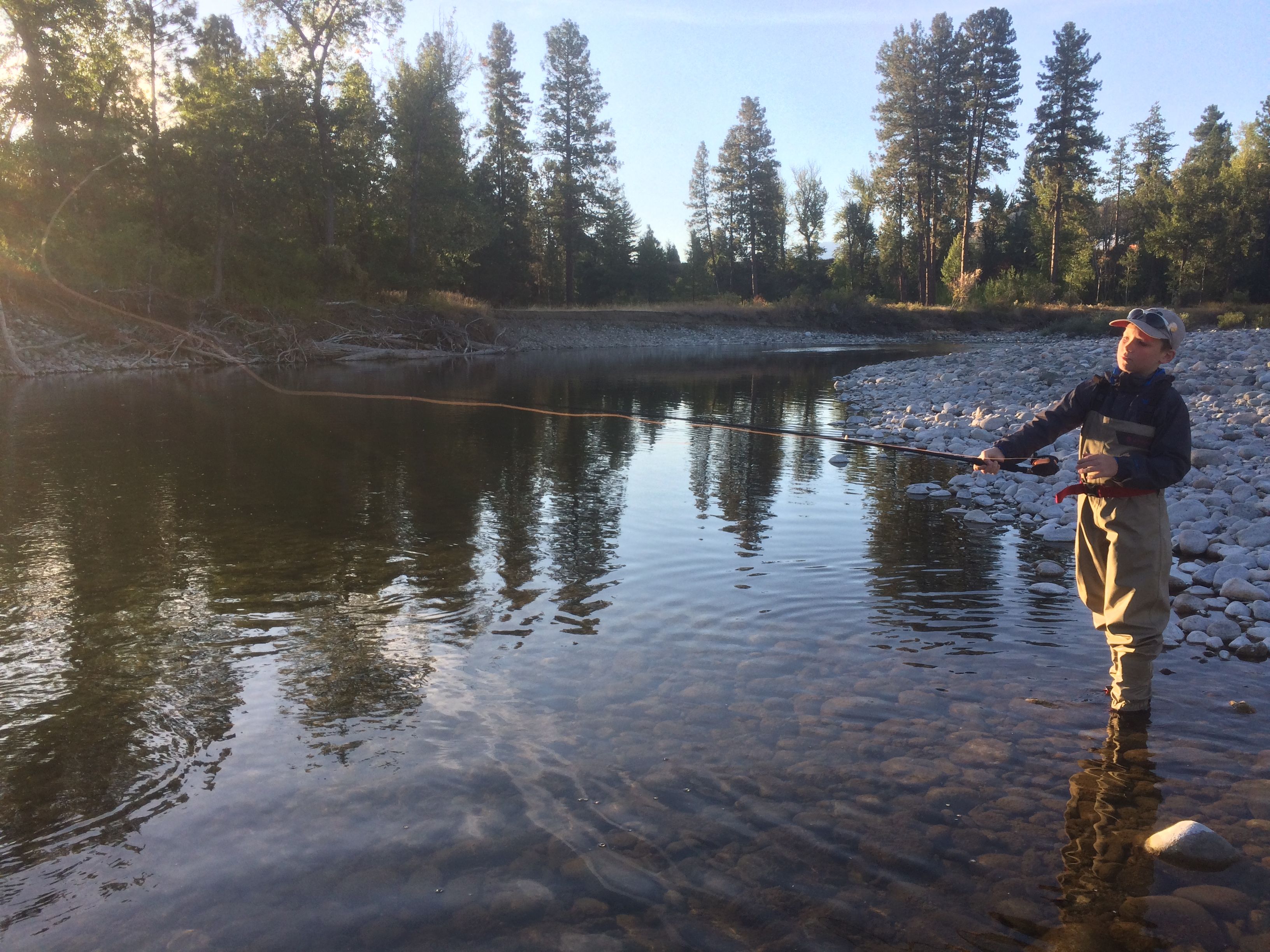 A boy casts a fly fishing rod on the Methow River.