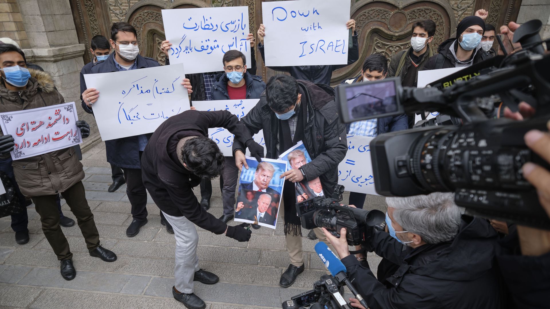 Photo of protesters in Iran burning portraits of Donald Trump and Joe Biden