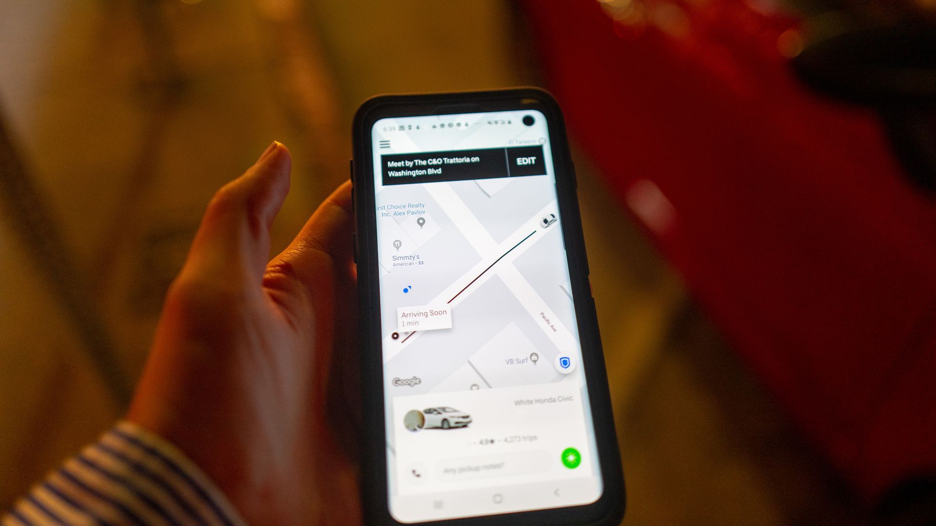 A photo of a hand holding a smartphone running the Uber app