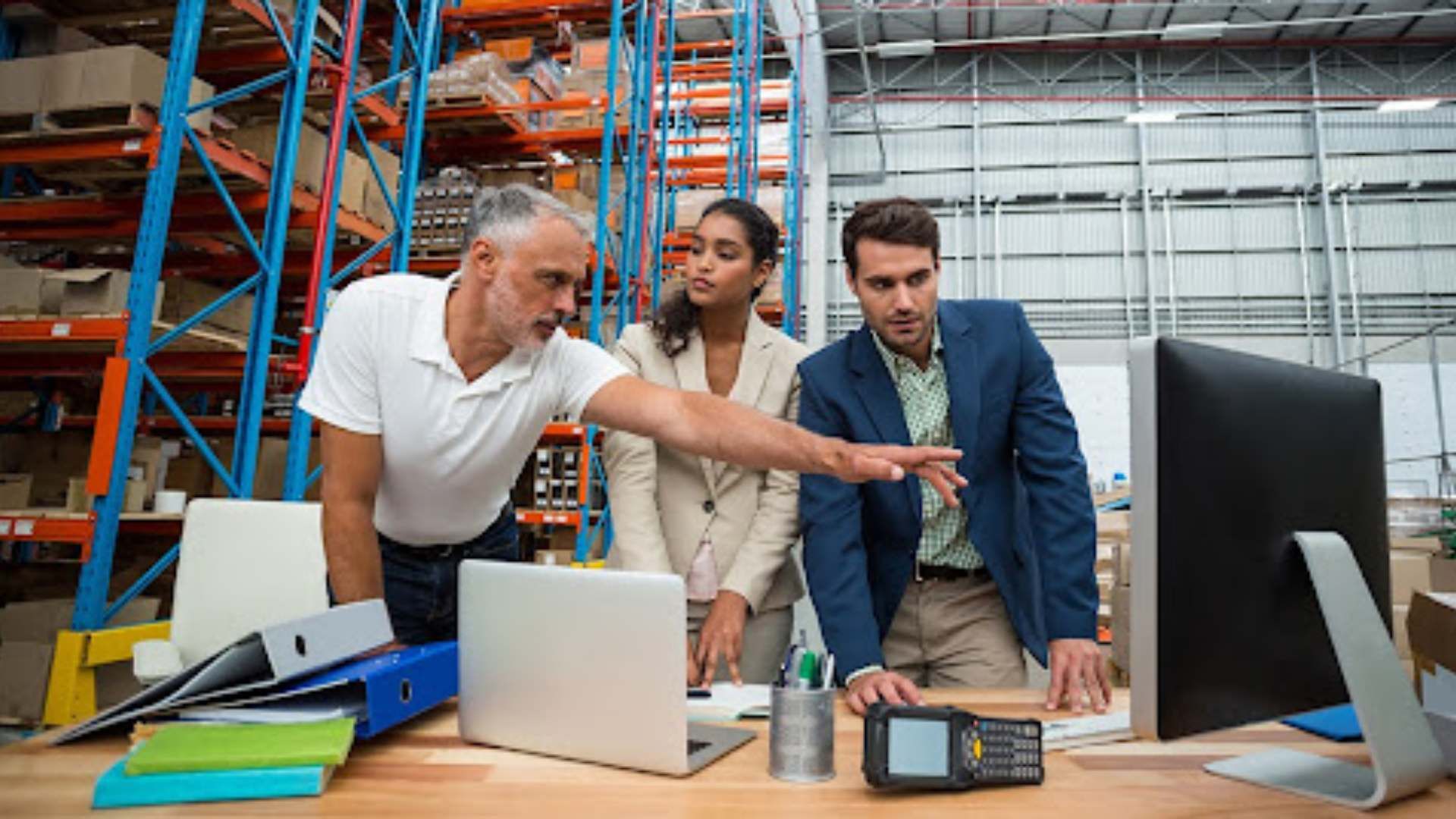 Three people working at a desk.
