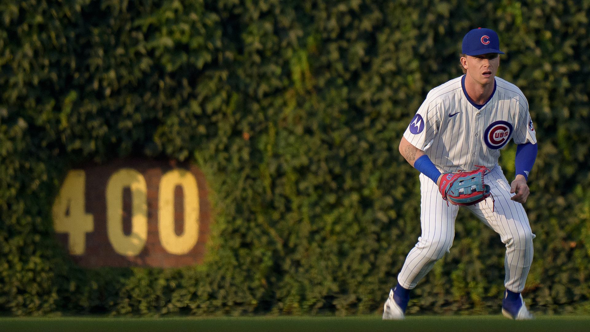 Photo of a baseball player in the outfield next to a 400 sign. 