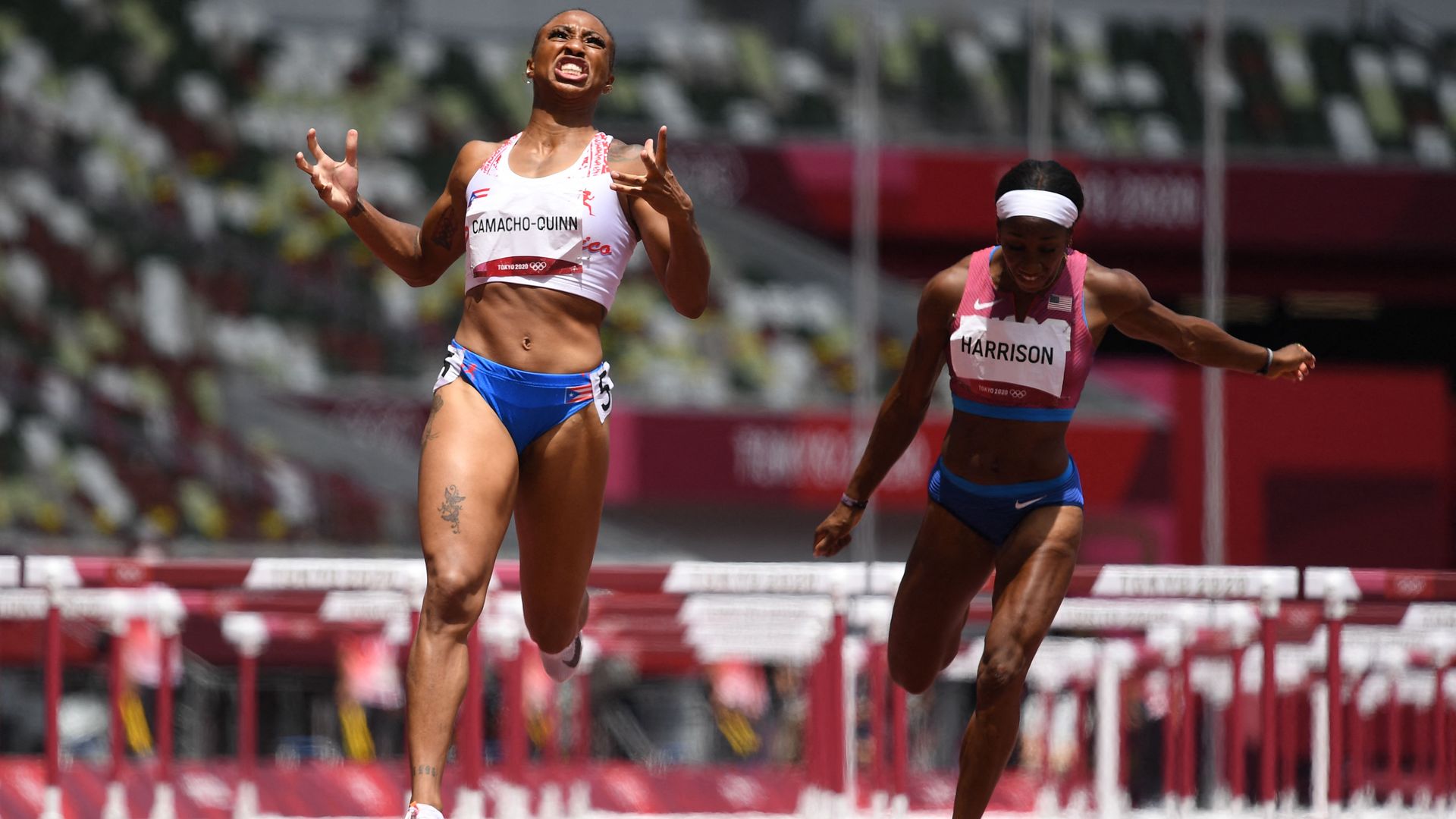 Puerto Rico's Jasmine Camacho-Quinn (L) wins ahead of USA's Kendra Harrison in the women's 100m hurdles final during the Tokyo 2020 Olympic Games  on August 2