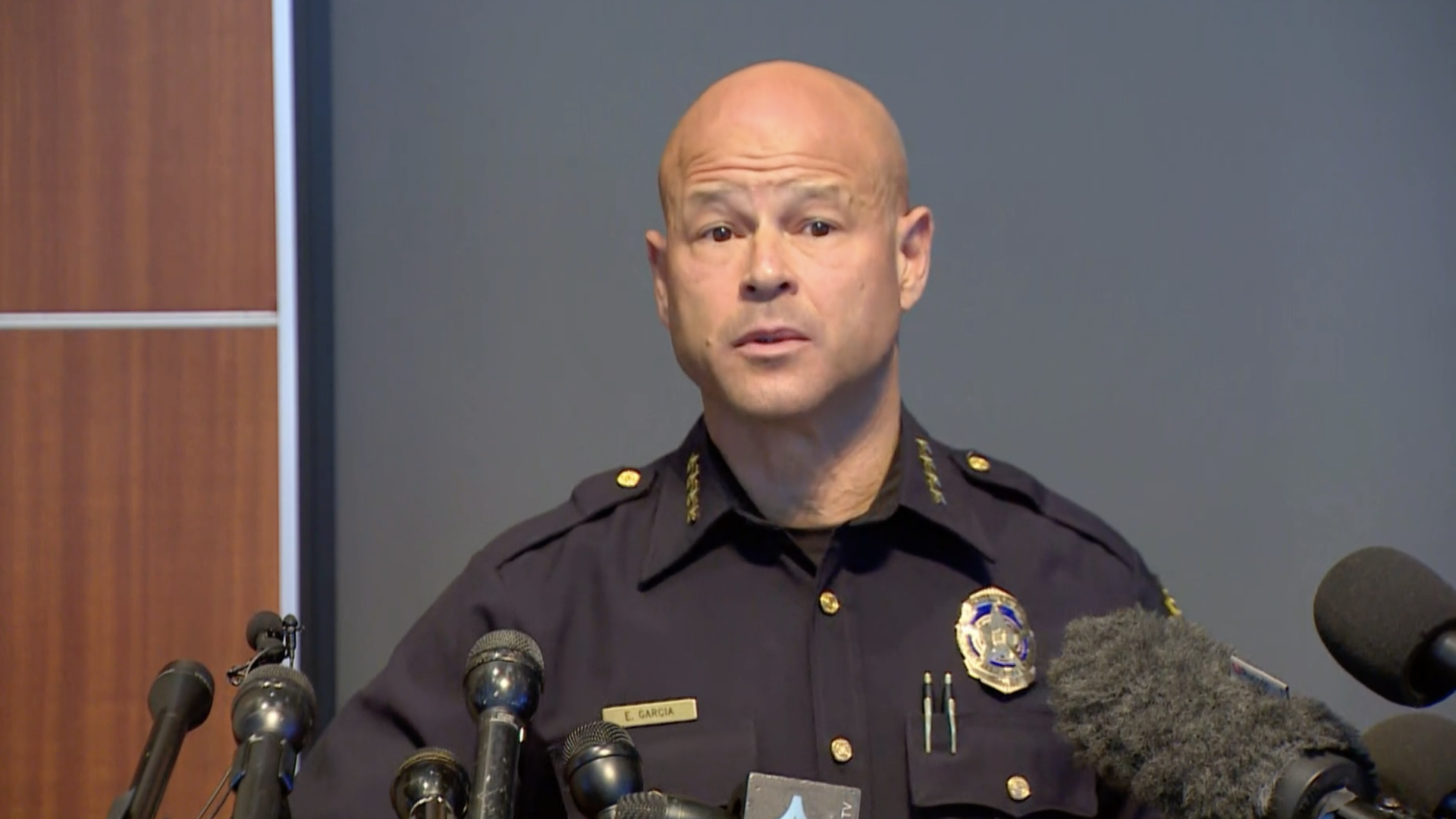 Police Chief Eddie Garcia in front of a row of microphones