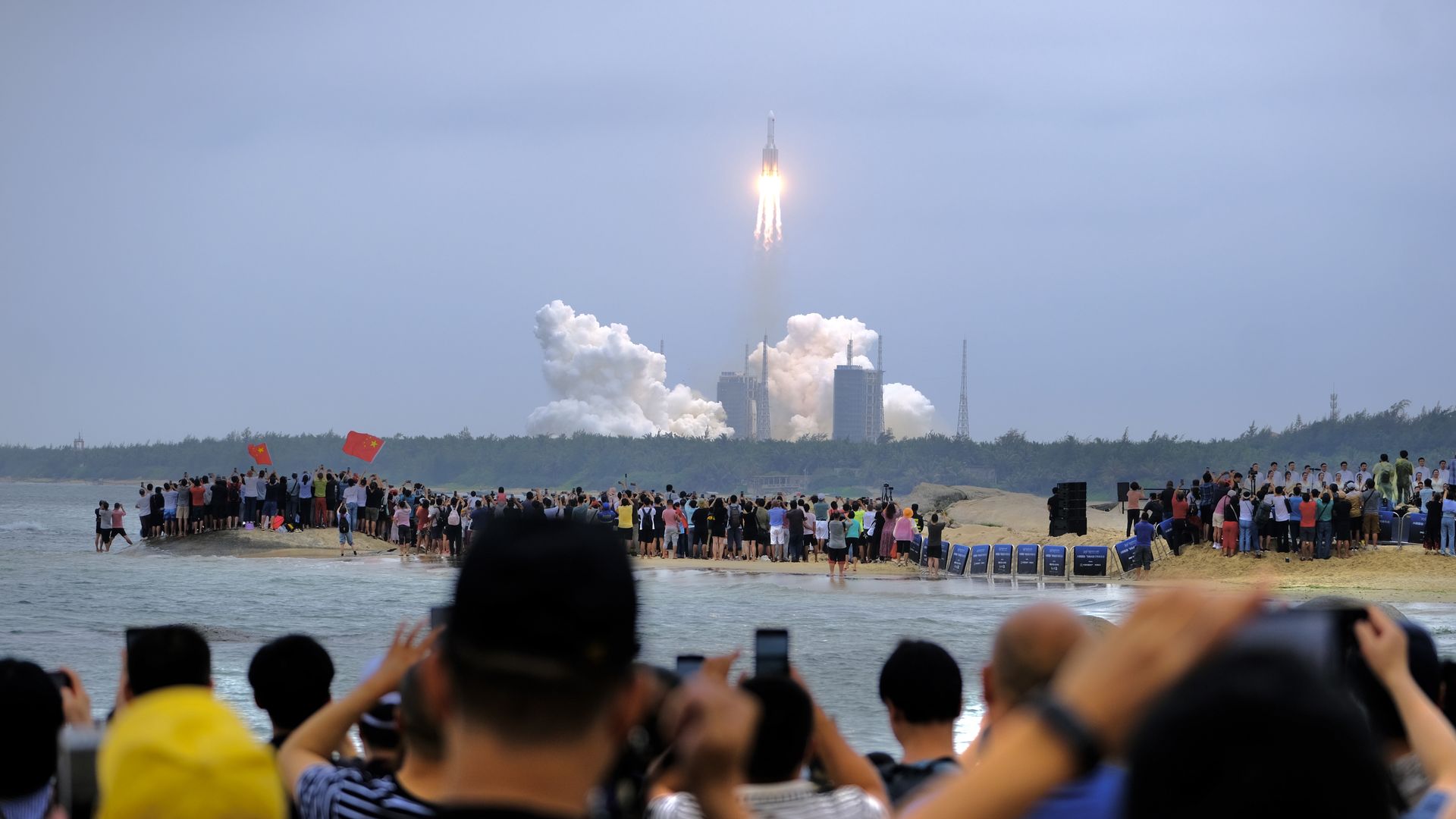 People watch the Long March-5B Y2 rocket carrying the core module of China's space station, Tianhe, blasting off from the Wenchang Spacecraft Launch Site on April 29