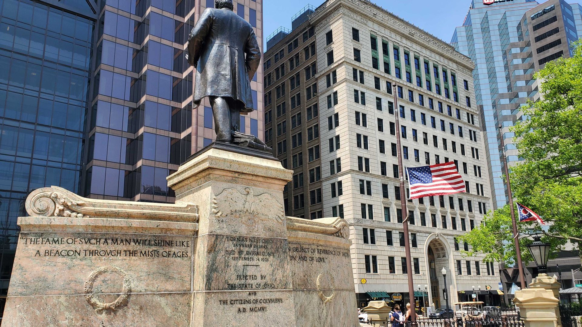 A flag at half-staff next to a statue of President McKinley.