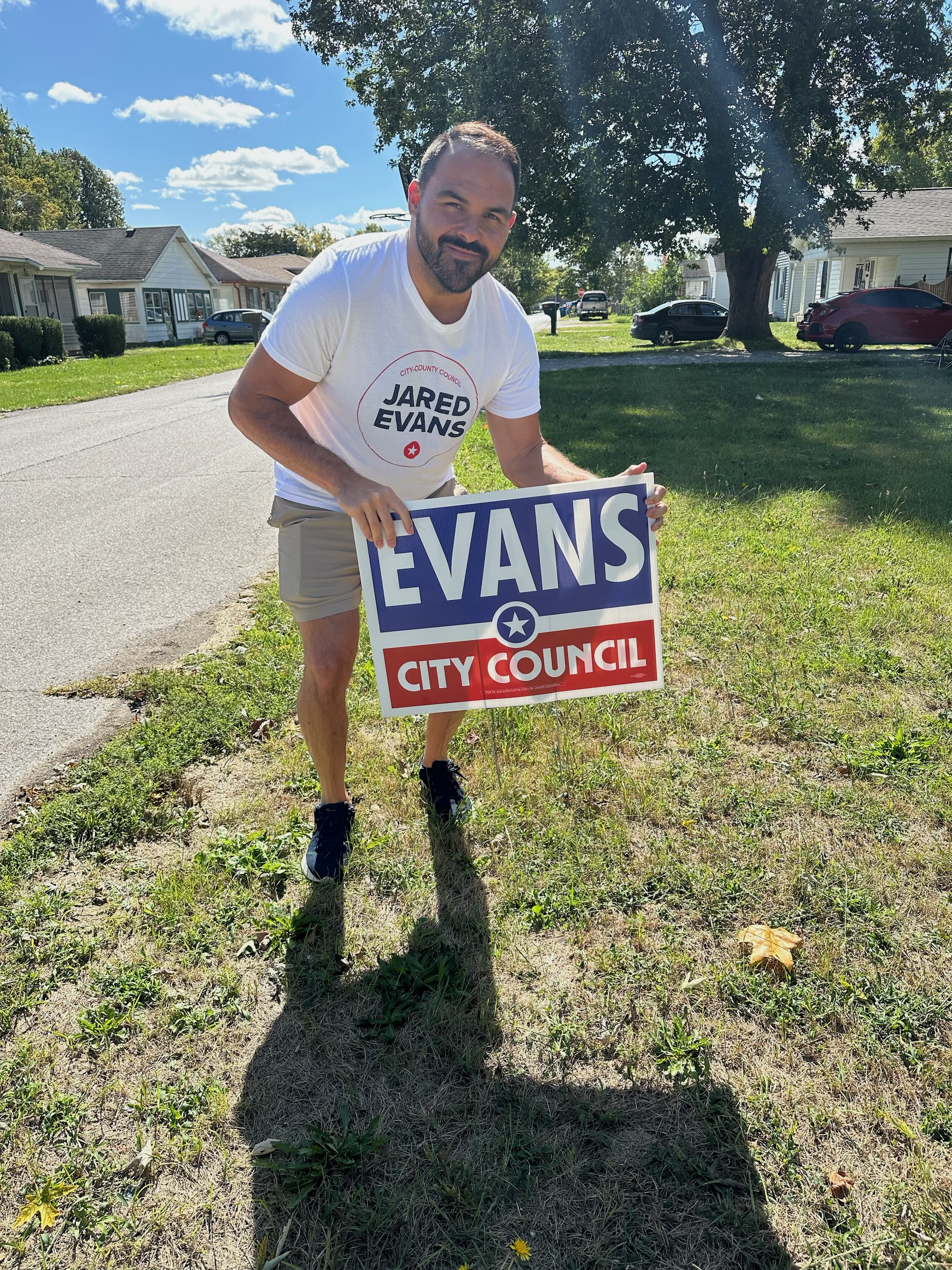 Jared Evans holding a yard sign.