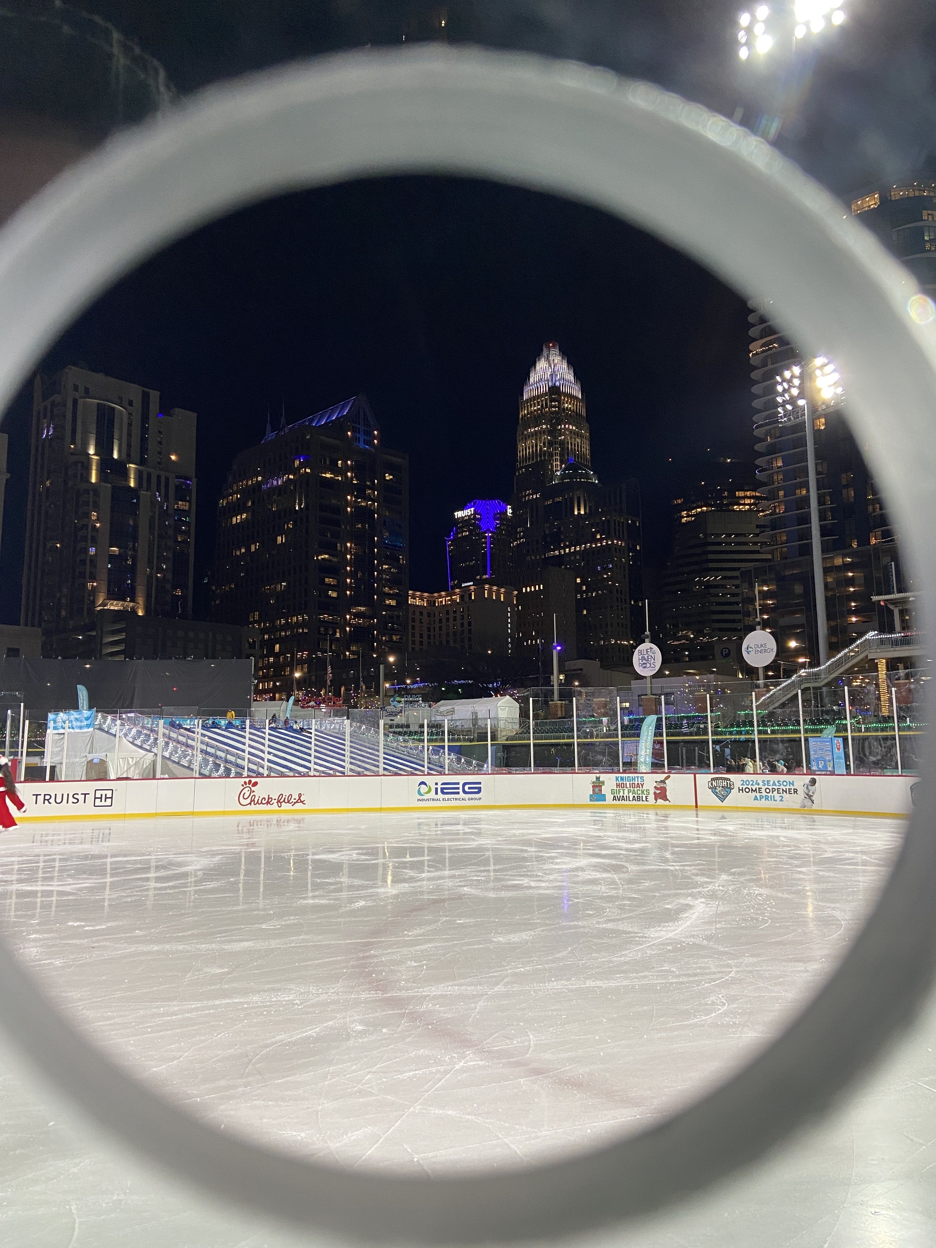 Ice skating rink at Truist Field with the Charlotte skyline in the background.
