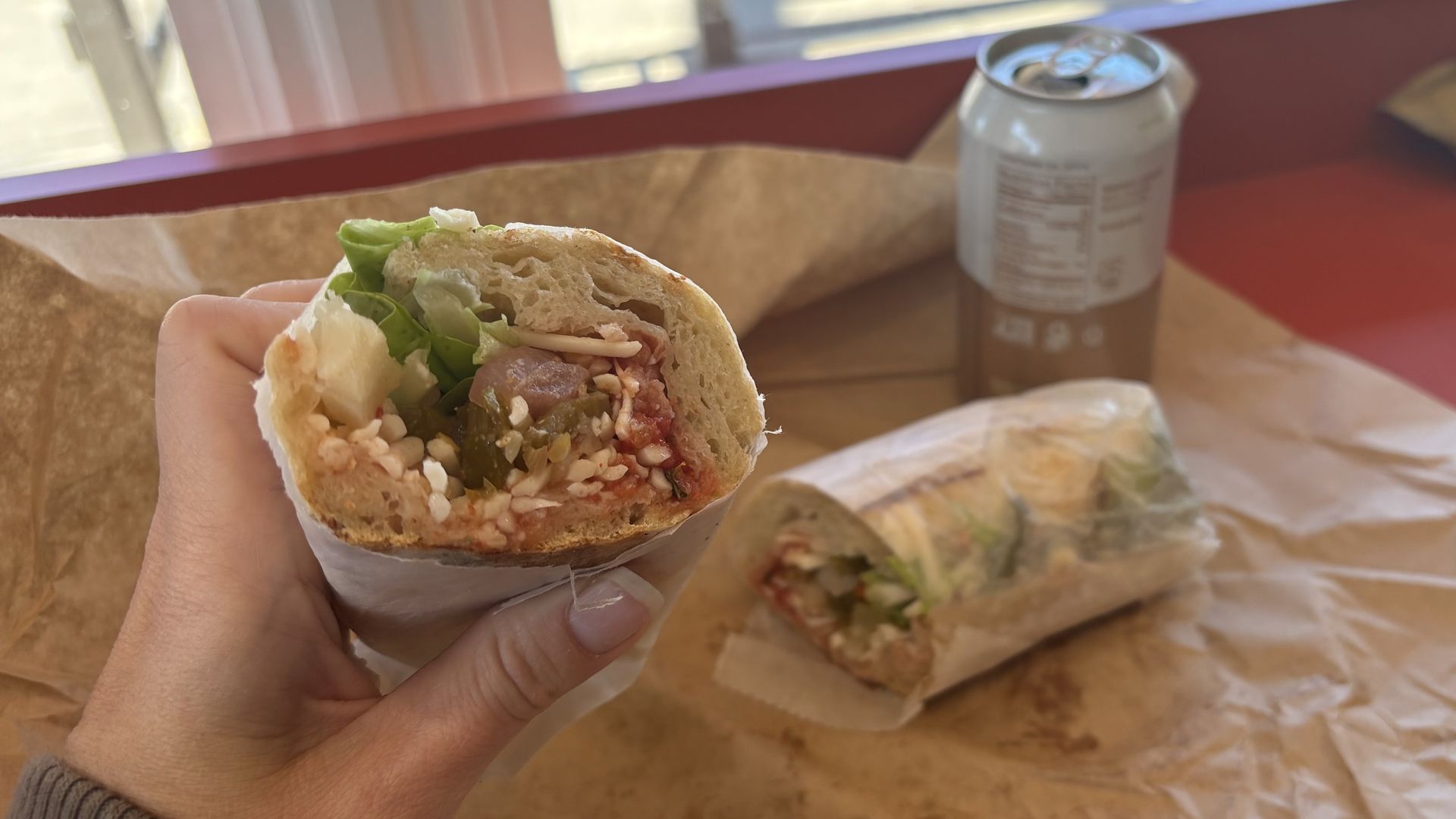 A hand holding a sandwich 