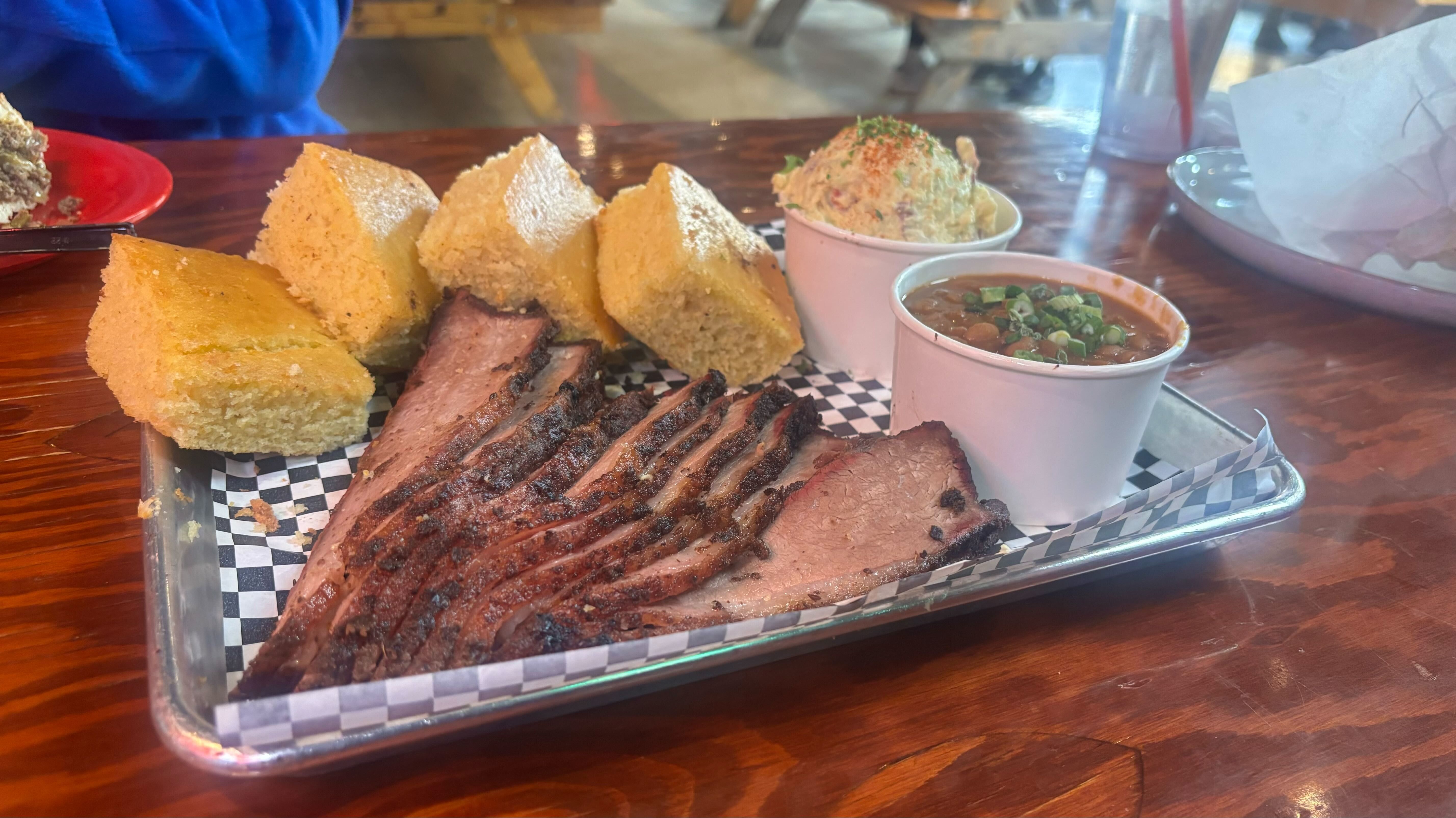 A plate with brisket, cornbread and other sides