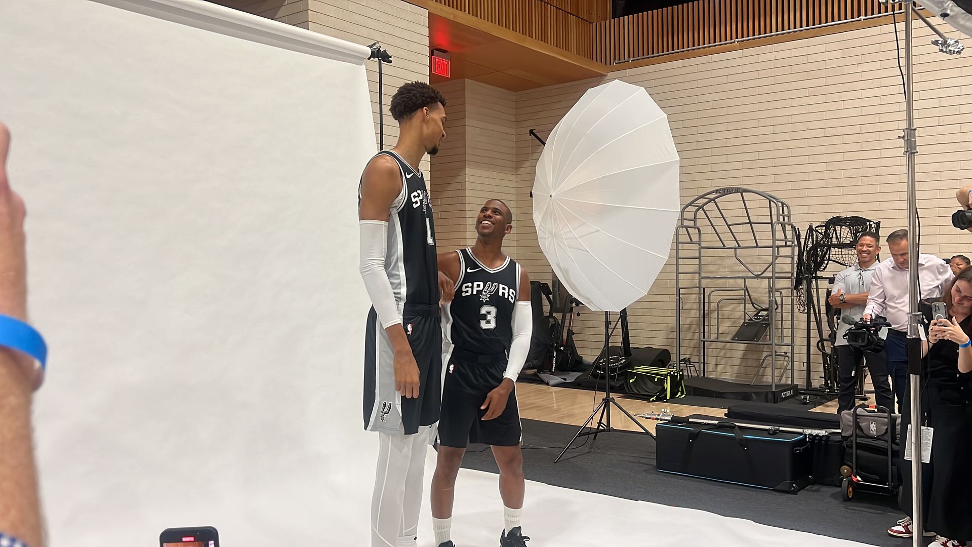 Chris Paul looks up at Victor Wembanyama.