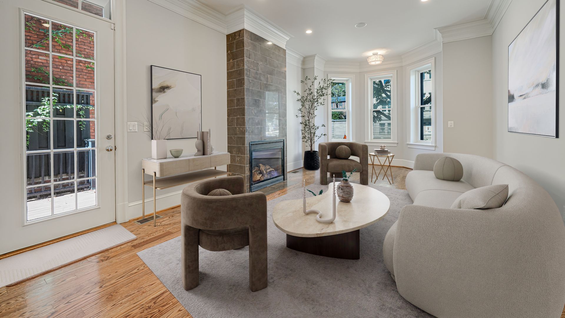A photo showing a living room with a brick fireplace and bay windows.