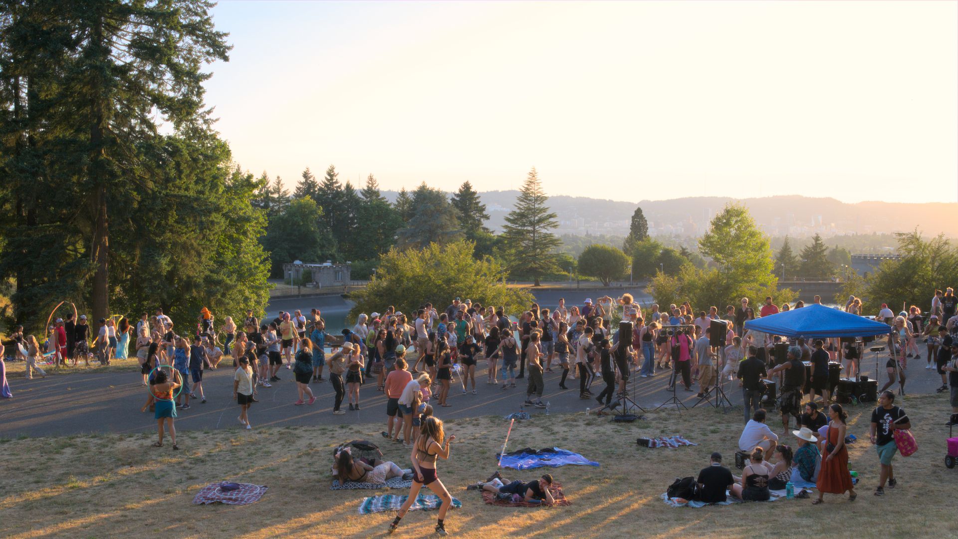 People dancing on a hillside at sunset