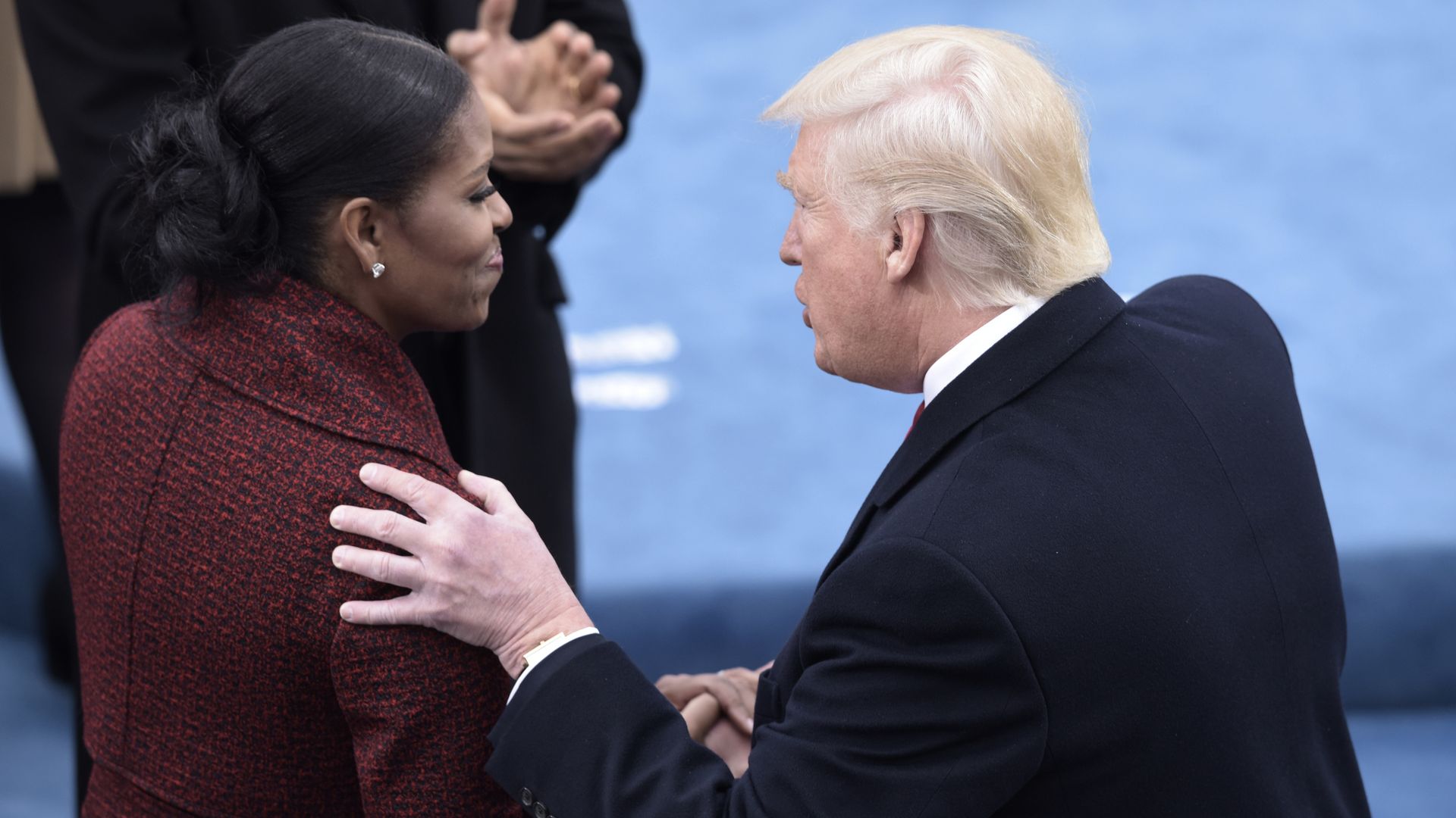 President Trump and Michelle Obama shake hands.