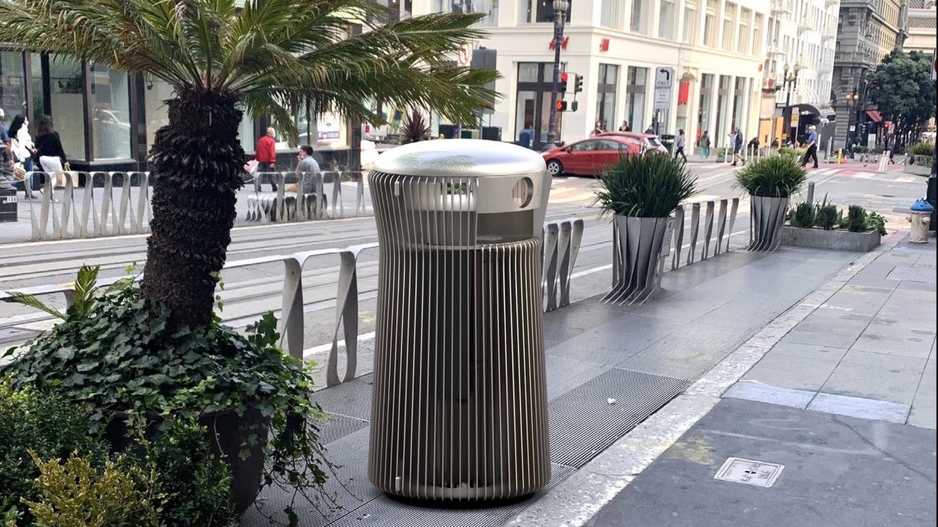 Silver trash can on the sidewalk.