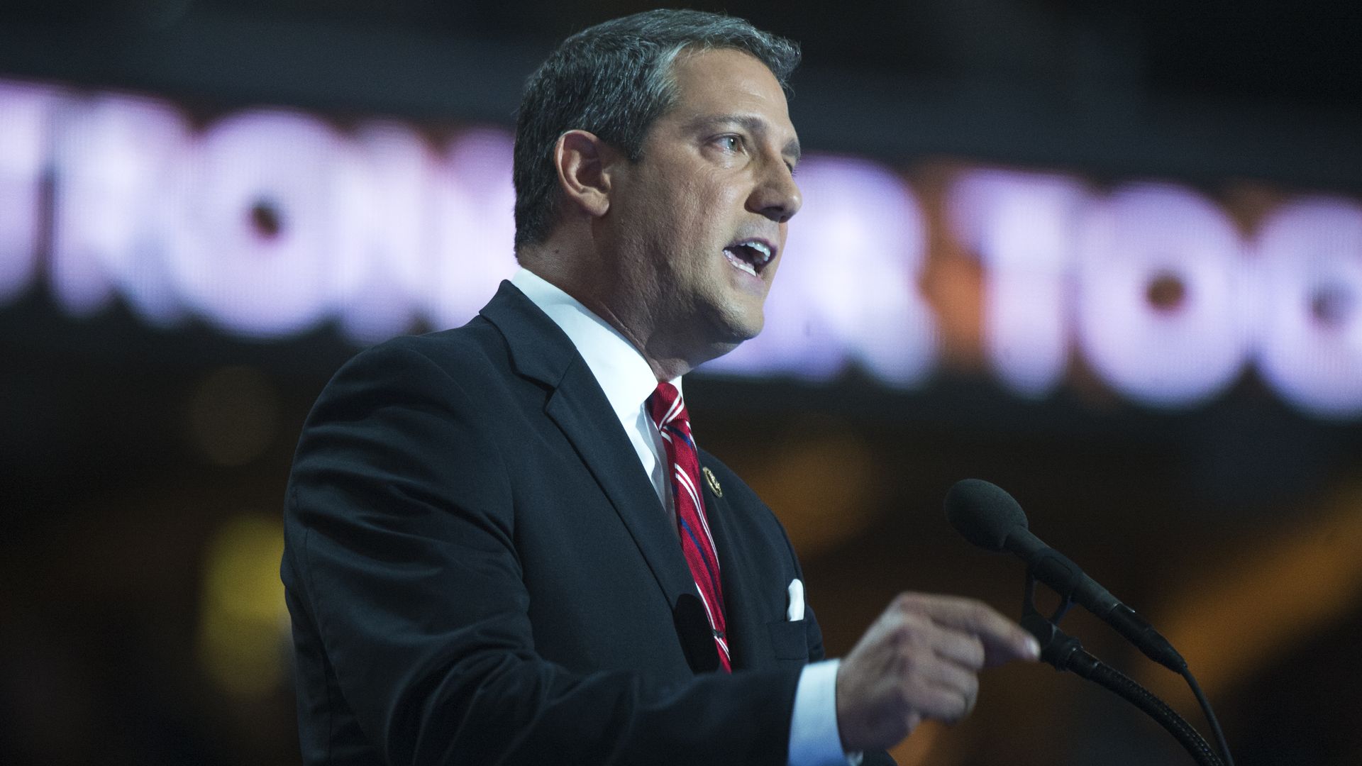 In this image, Tim Ryan speaks into a microphone on stage. 