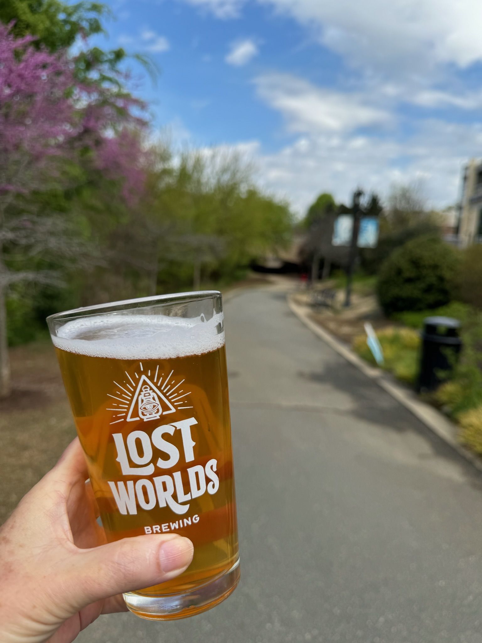 hand holding beer on a walking trail
