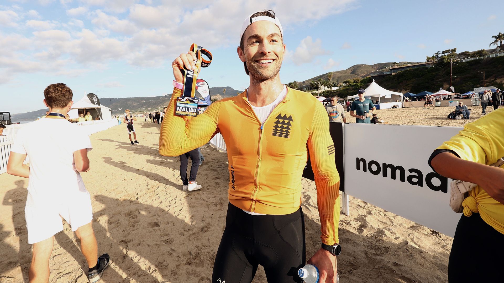 Chace Crawford holds up a triathalon medal