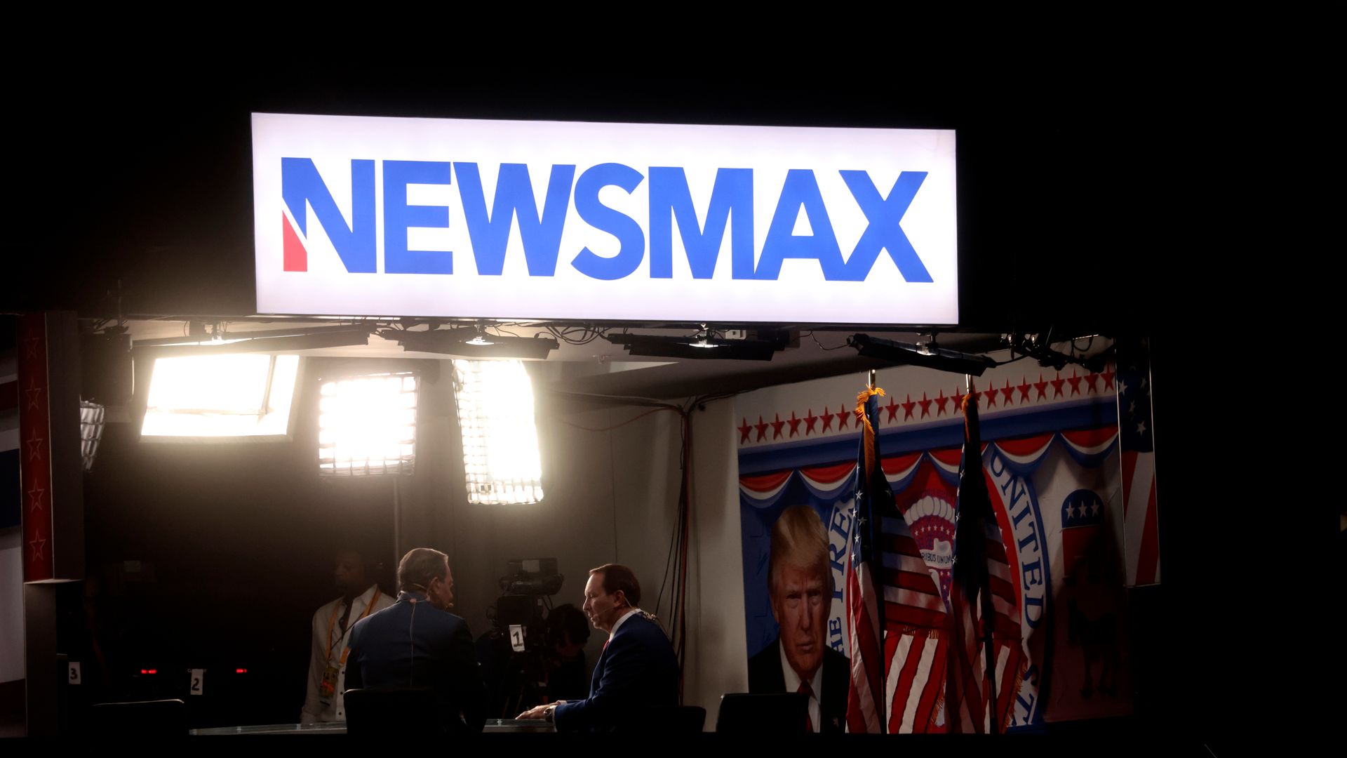 Newsmax signage during the Republican National Convention (RNC) at the Fiserv Forum in Milwaukee, Wisconsin, US, on Thursday, July 18, 2024. The RNC chairman warned against complacency when his party concludes its official nominating jamboree this week with polls predicting ex-President Donald Trump