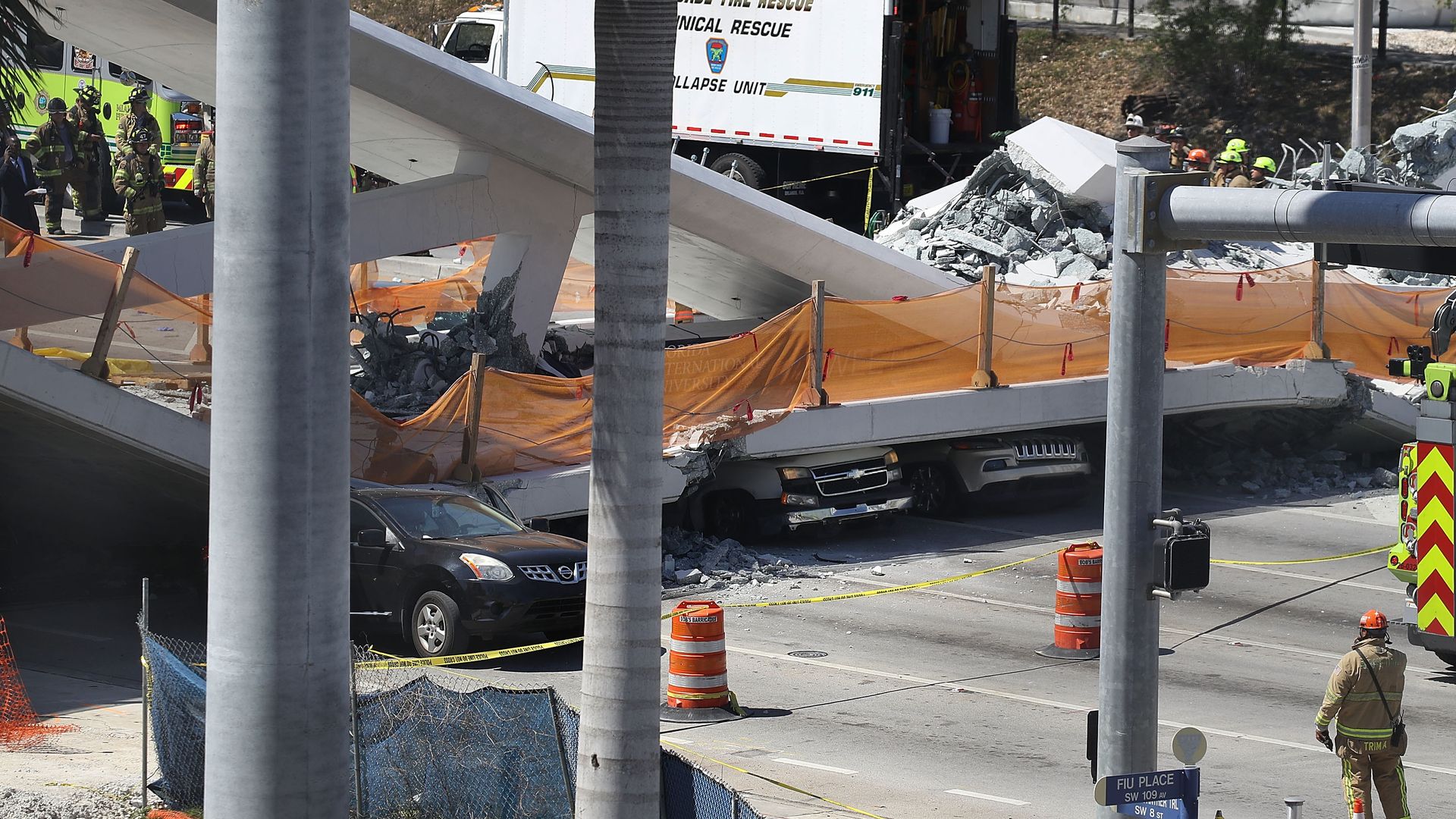 Vehicles are seen trapped under the collapsed pedestrian bridge.
