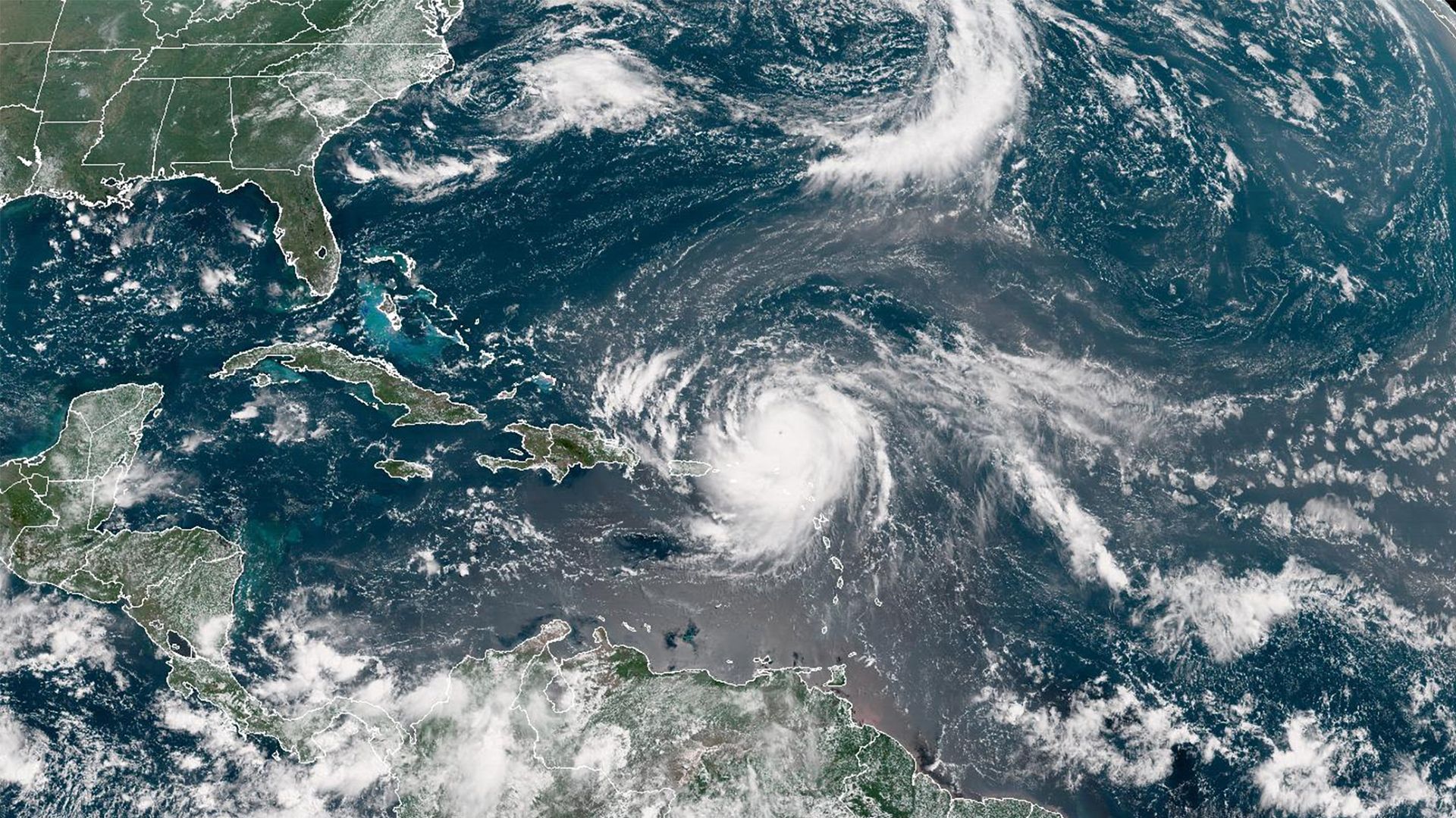 Satellite image of the Caribbean and Atlantic showing a large hurricane with a clear eye near the Lesser Antilles, surrounded by cloud bands, over blue ocean waters.