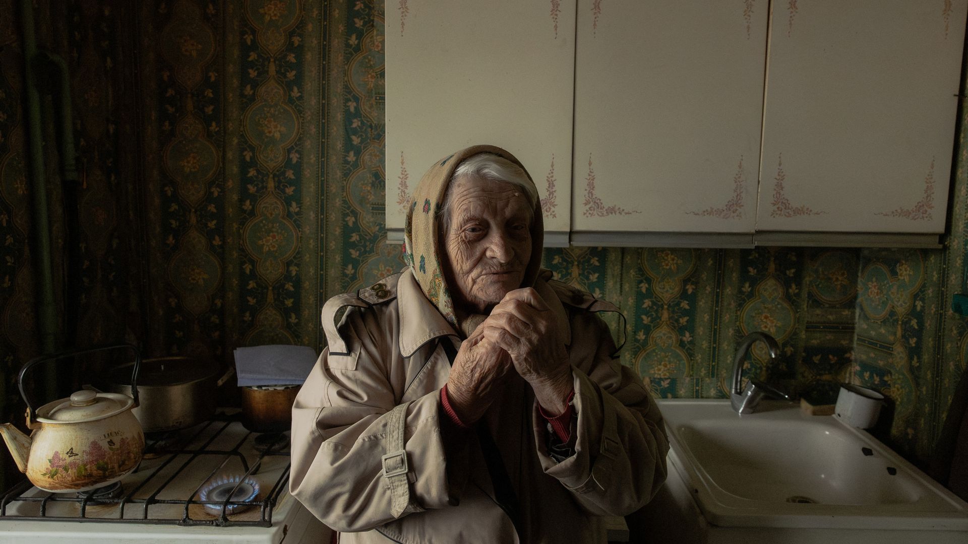 Old woman warms hands