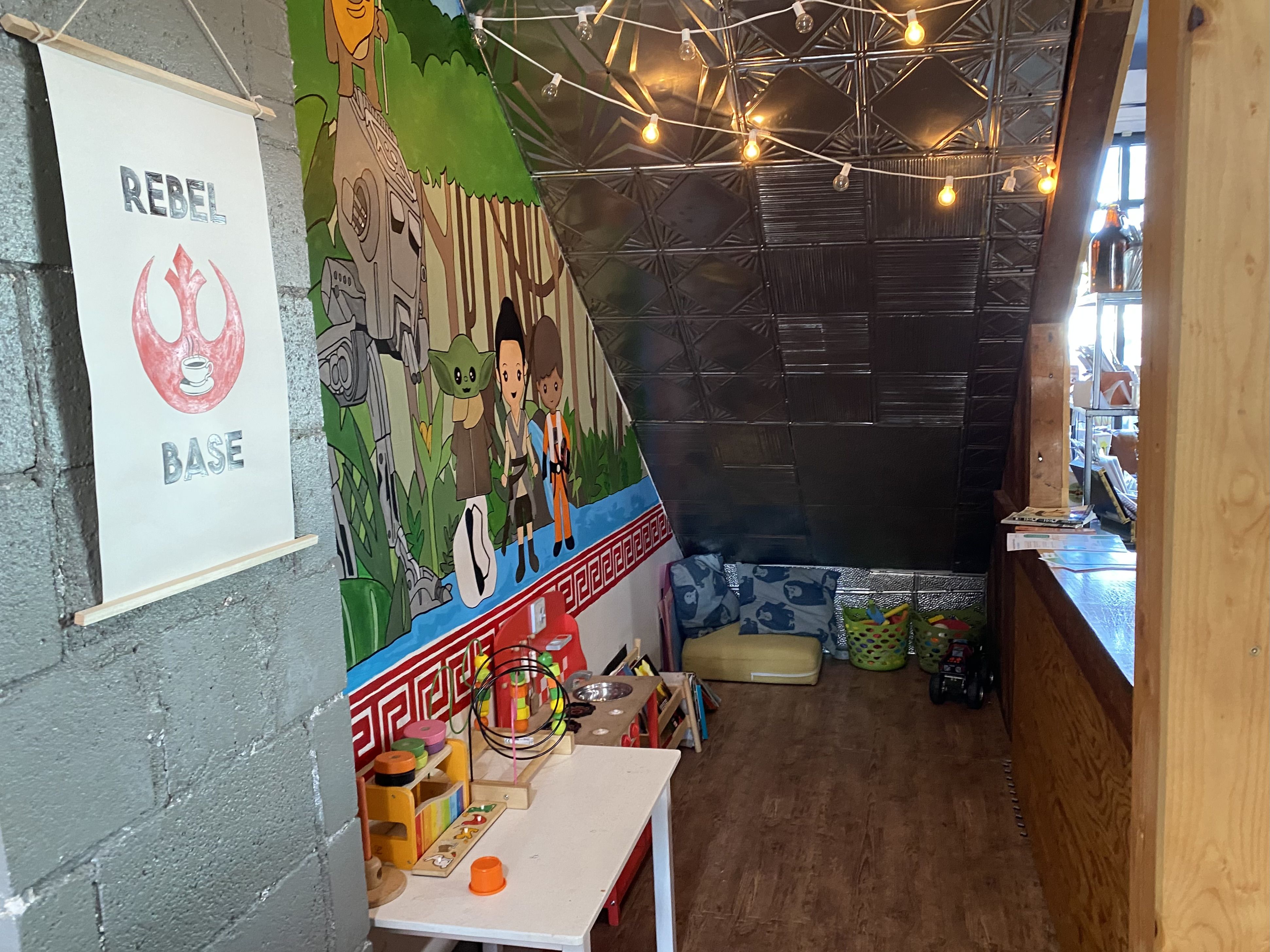 A view of a nook with kids toys and a mural.