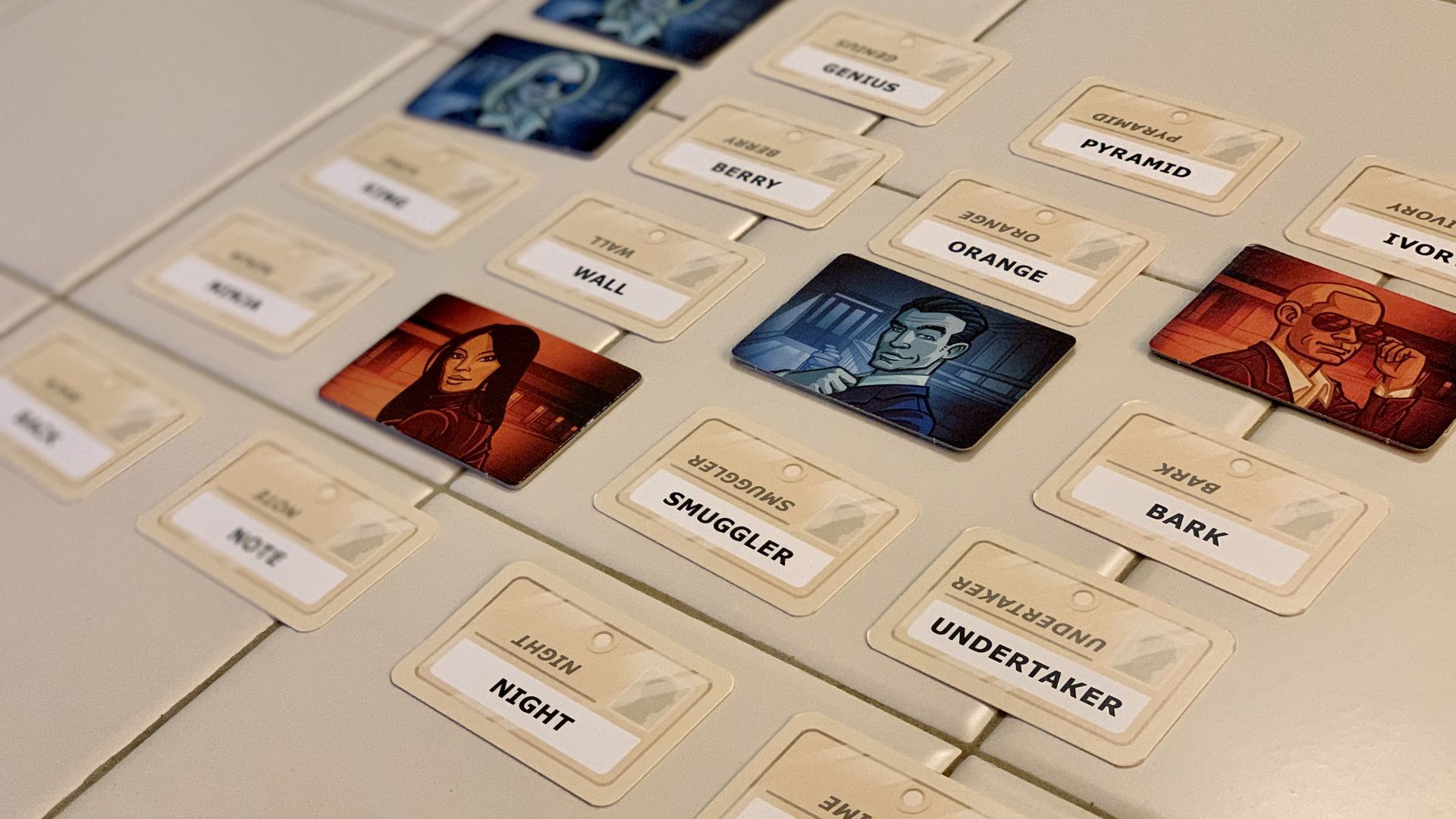 Photo of a board game in progress, with a grid of 25 cards showing words, some covered by characters
