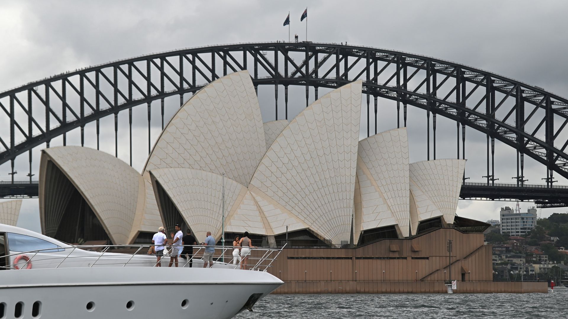  People sail past the Opera House and Harbour Bridge in Sydney on December 20, 2020, after authorities introduced a fresh round of restrictions to control a growing coronavirus outbreak in the city.