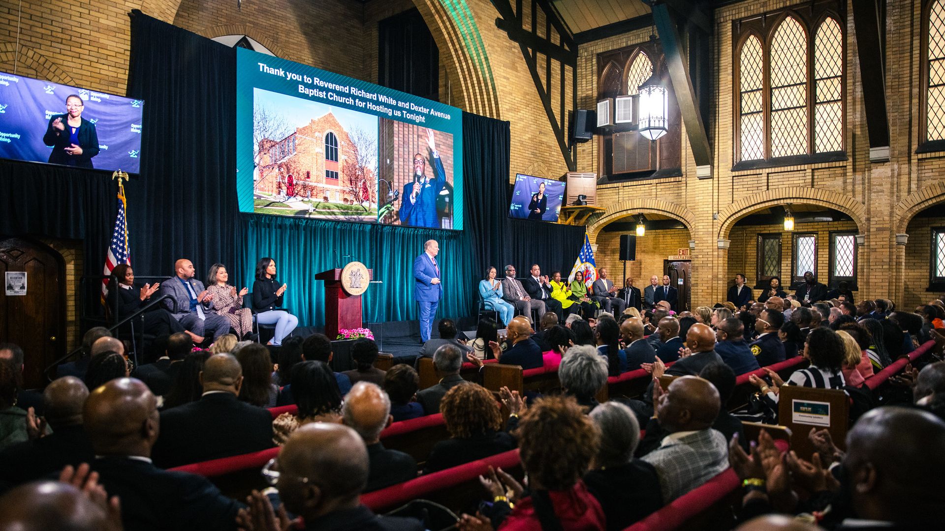 Duggan speaks in a church in front of a crowd.