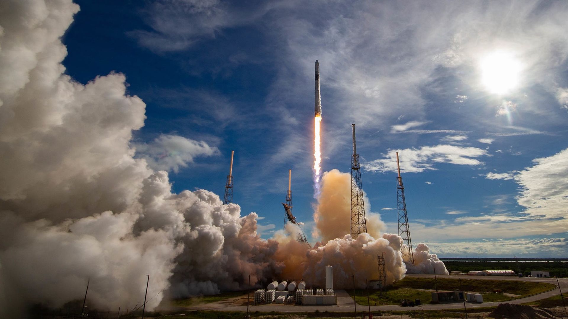 A SpaceX Falcon 9 rocket launching into a blue sky