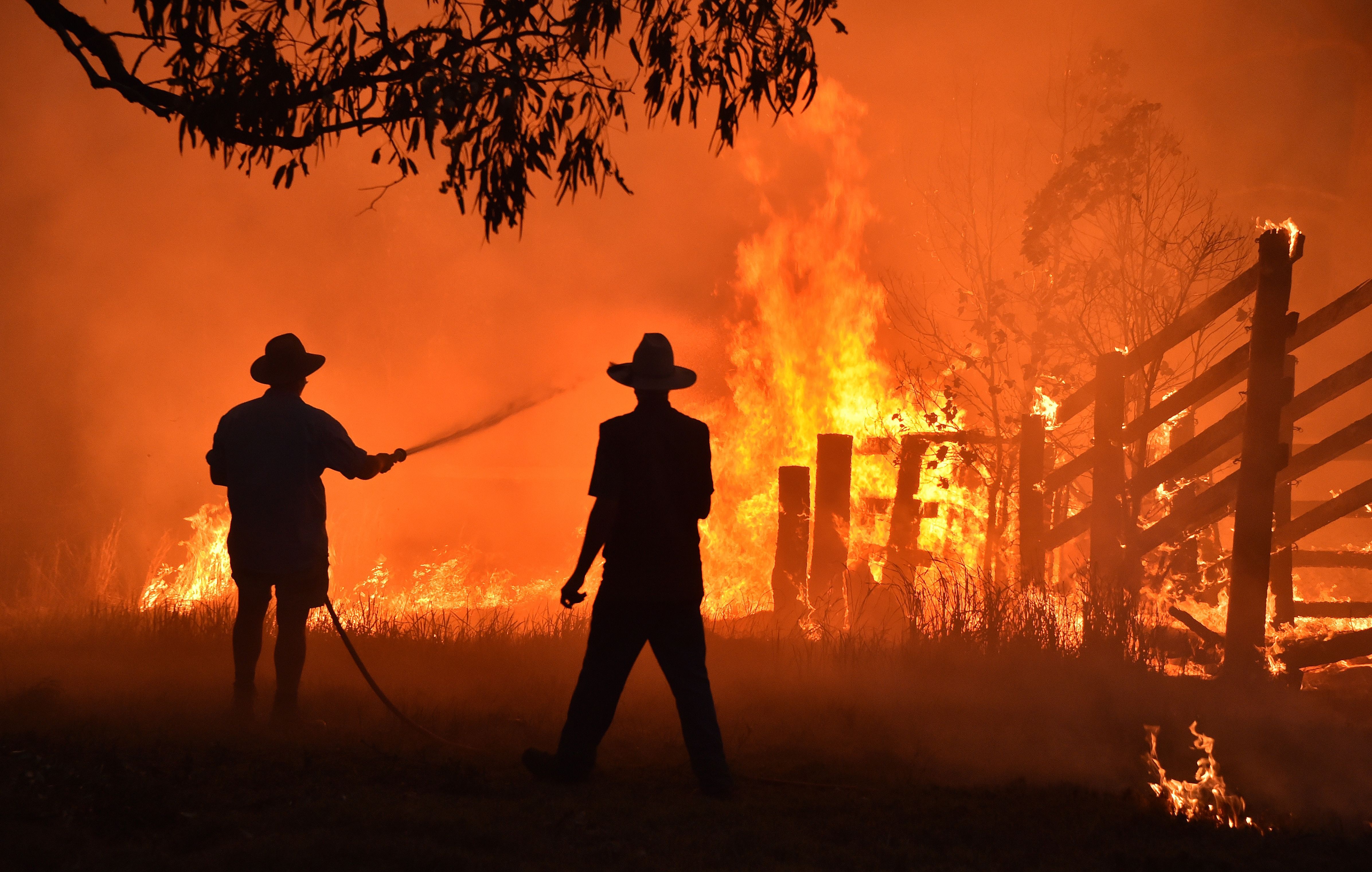 Residents defend a property from a bushfire at Hillsville near Taree, 350km north of Sydney 