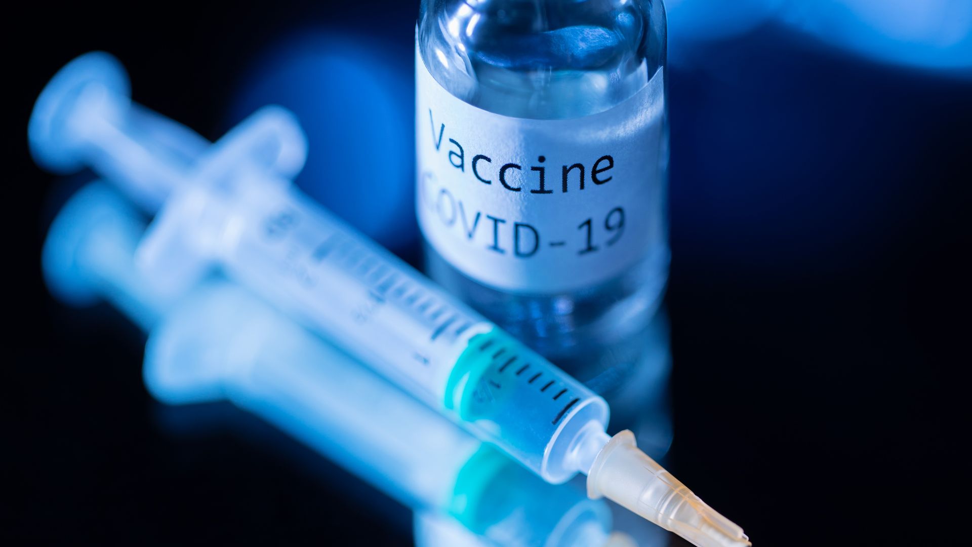 A syringe and bottle labeled "Vaccine COVID-19"