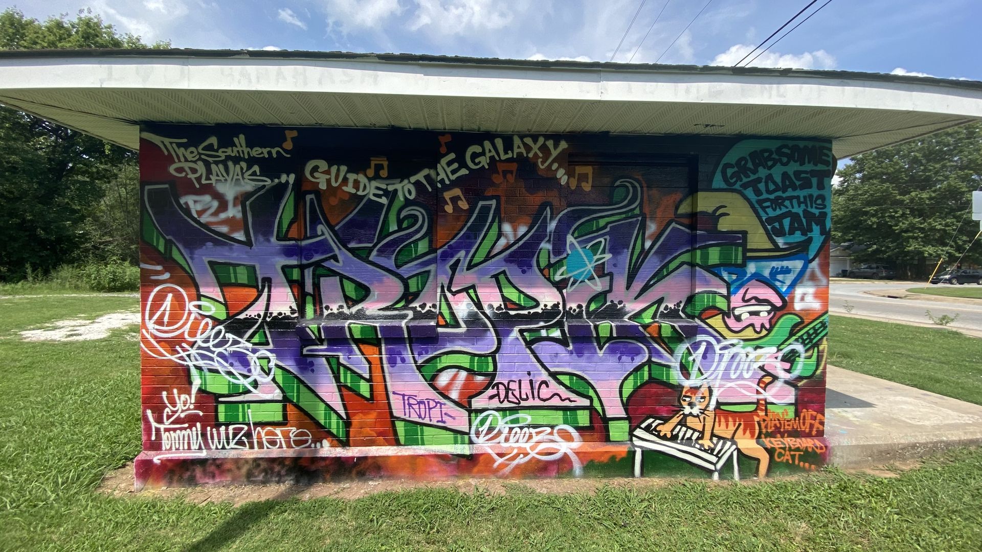 A wall of graffiti on an old brick building. 