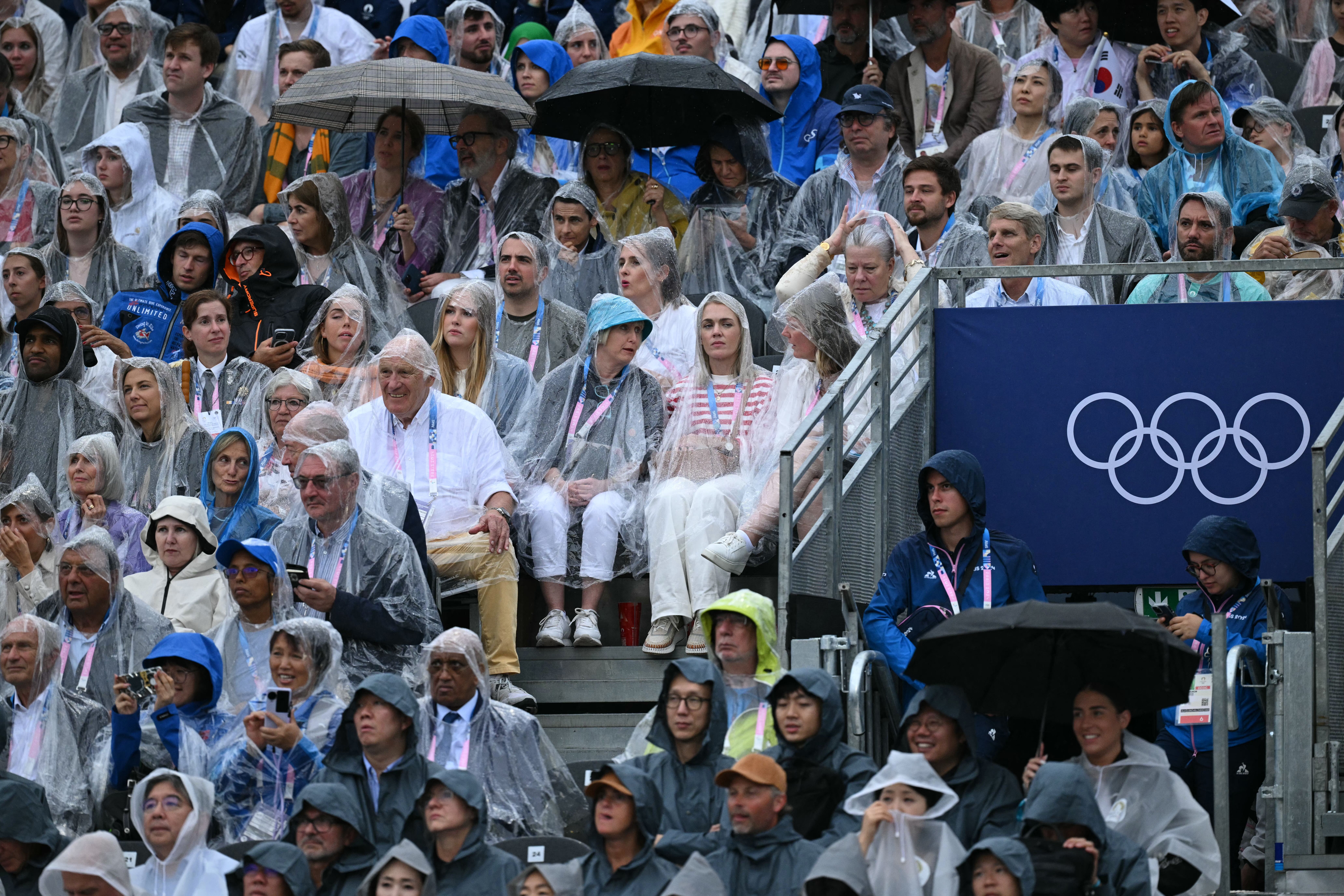 Guests wear rain covers during the opening ceremony of the Paris 2024 Olympic Games in Paris on July 26, 2024. (Photo by Oli SCARFF / AFP) (Photo by OLI SCARFF/AFP via Getty Images)