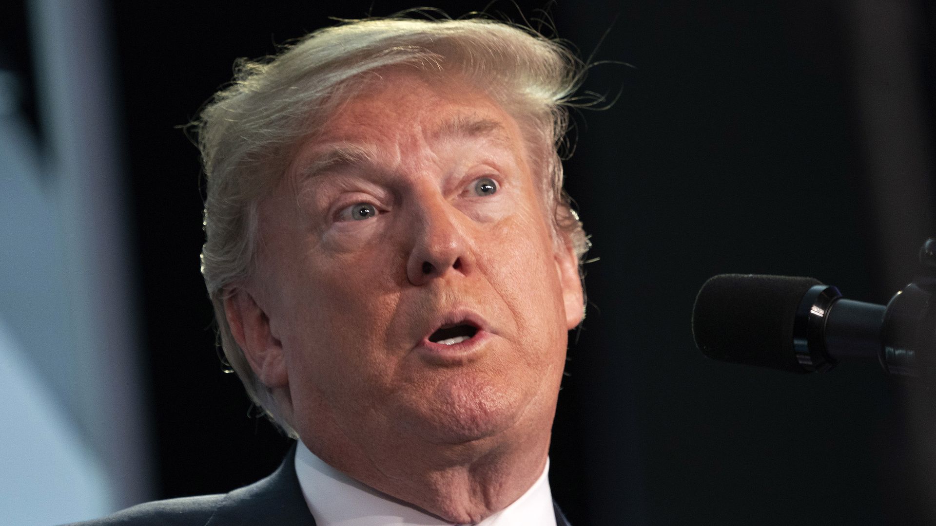 President Trump looking surprised with his eyes open wide and mouth making an "o" shape while speaking