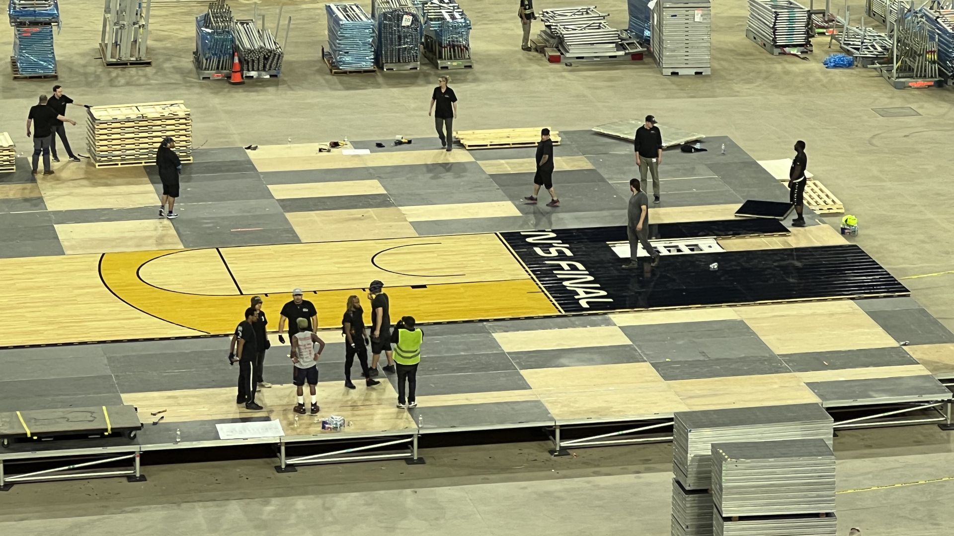 A high-angle shot of workers constructing the NCAA men's basketball tournament Final Four court inside NRG Stadium