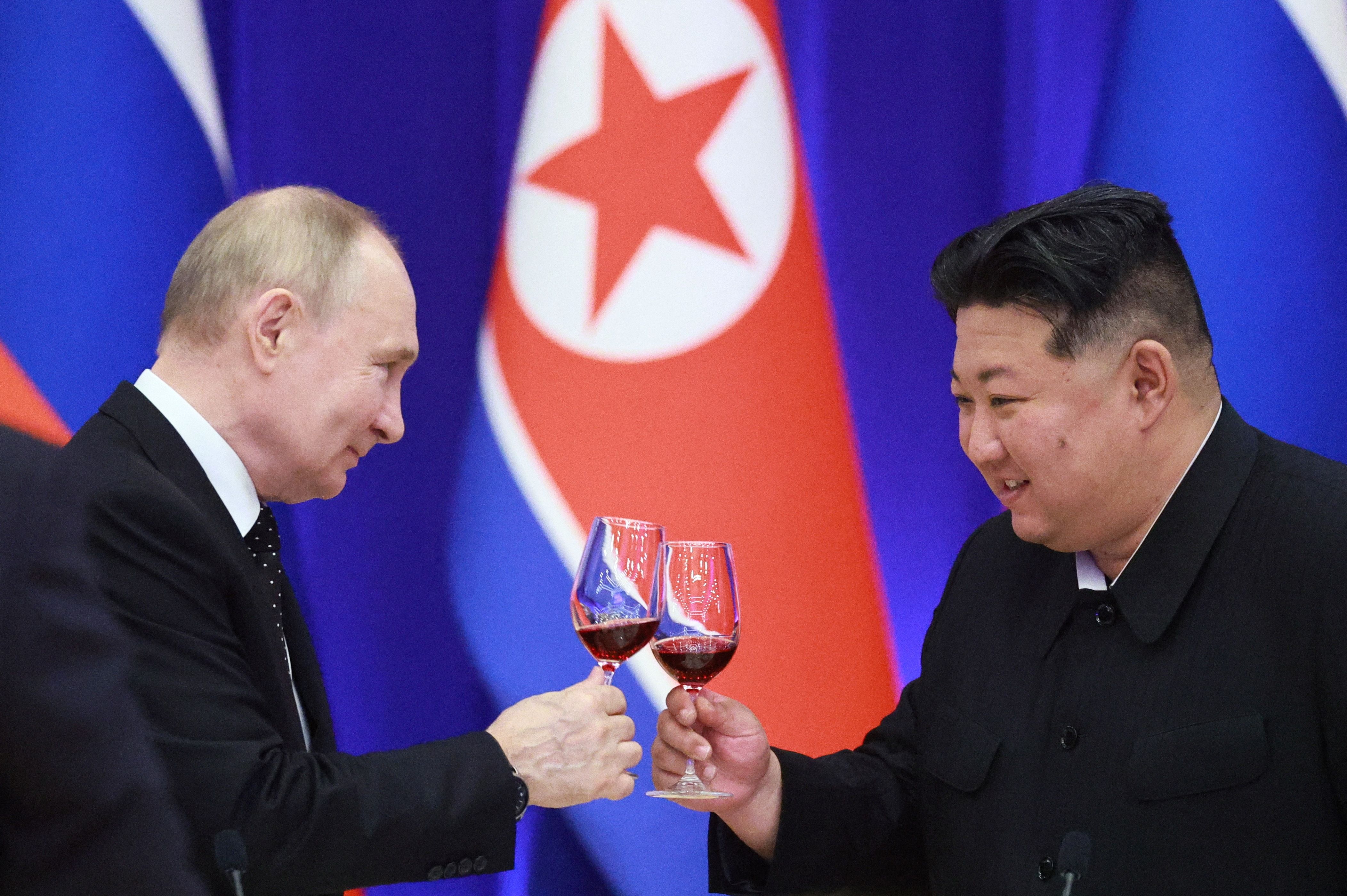 TOPSHOT - In this pool photograph distributed by the Russian state agency Sputnik, Russian President Vladimir Putin and North Korean leader Kim Jong Un toast during a reception at the Mongnangwan Reception House in Pyongyang on June 19, 2024. Putin enjoyed a red carpet welcome, a military ceremony a