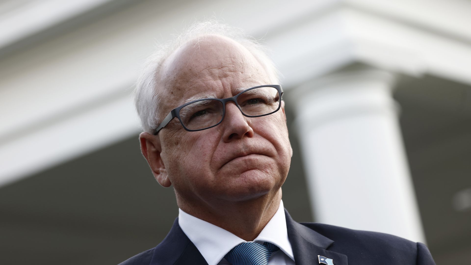 Tim Walz looking serious with glasses