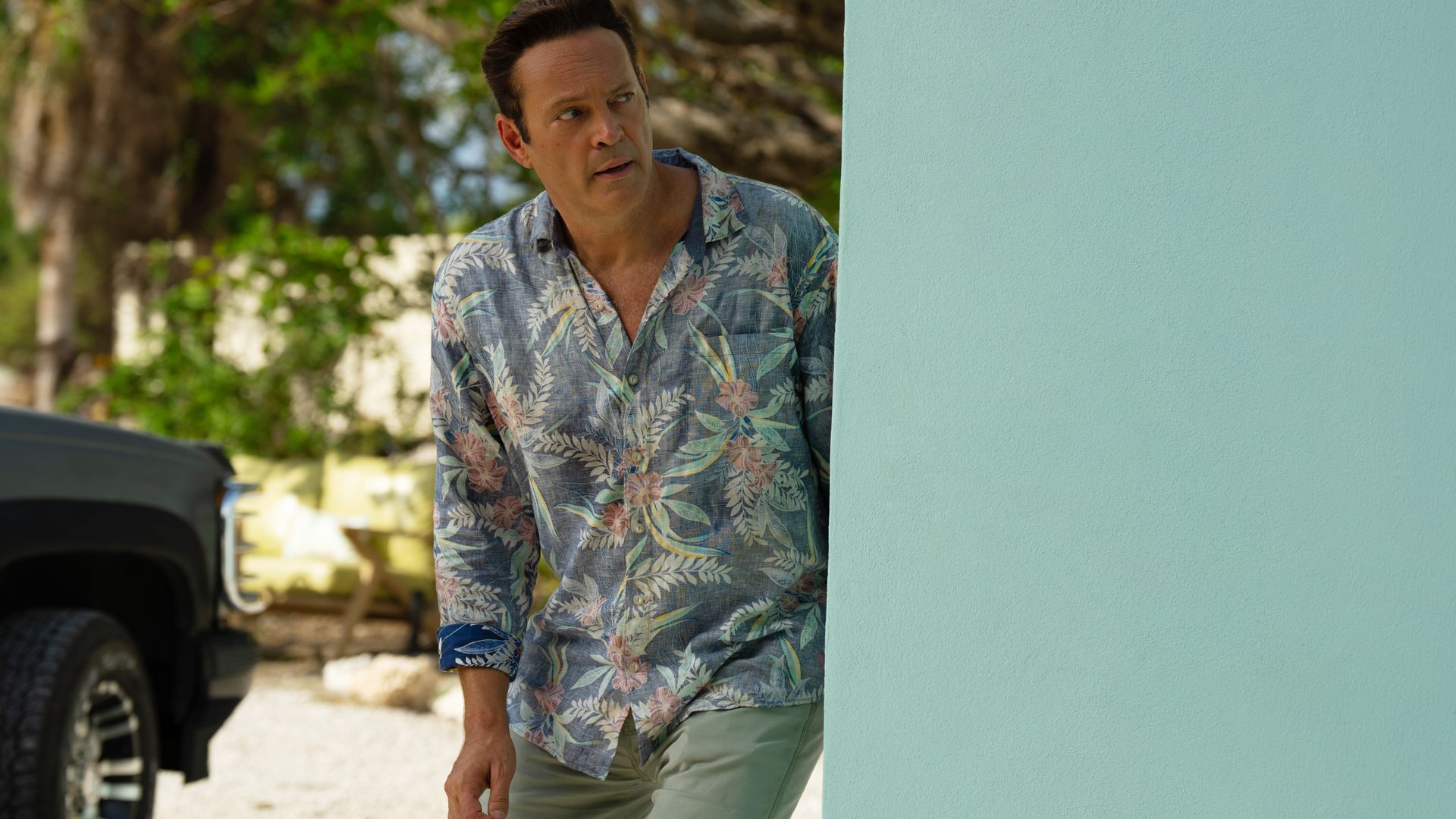 Vince Vaughn's character Andrew Yancy peeks around a corner nervously in an image from the series "Bad Monkey."